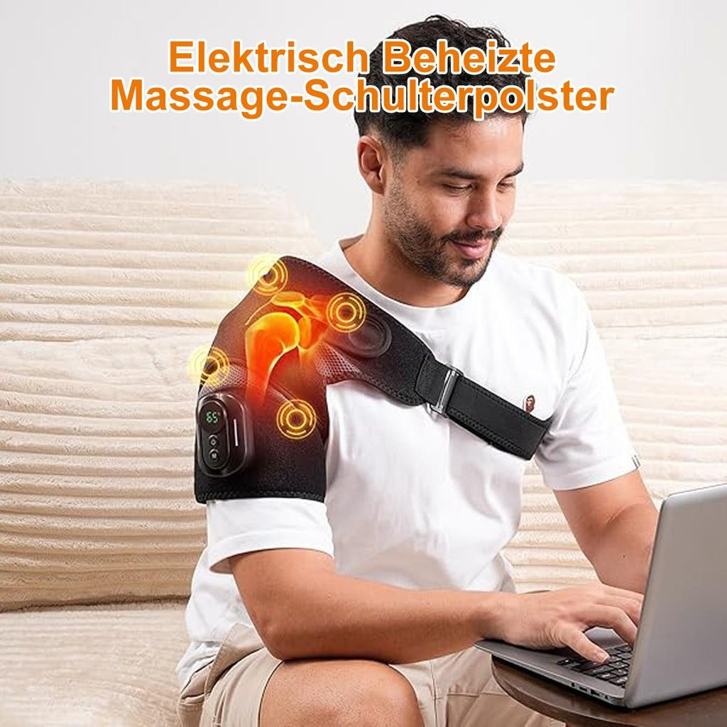 Ein Mann sitzt auf einer Couch und trägt eine elektrische Schultermassagebandage, während er an einem Laptop arbeitet.