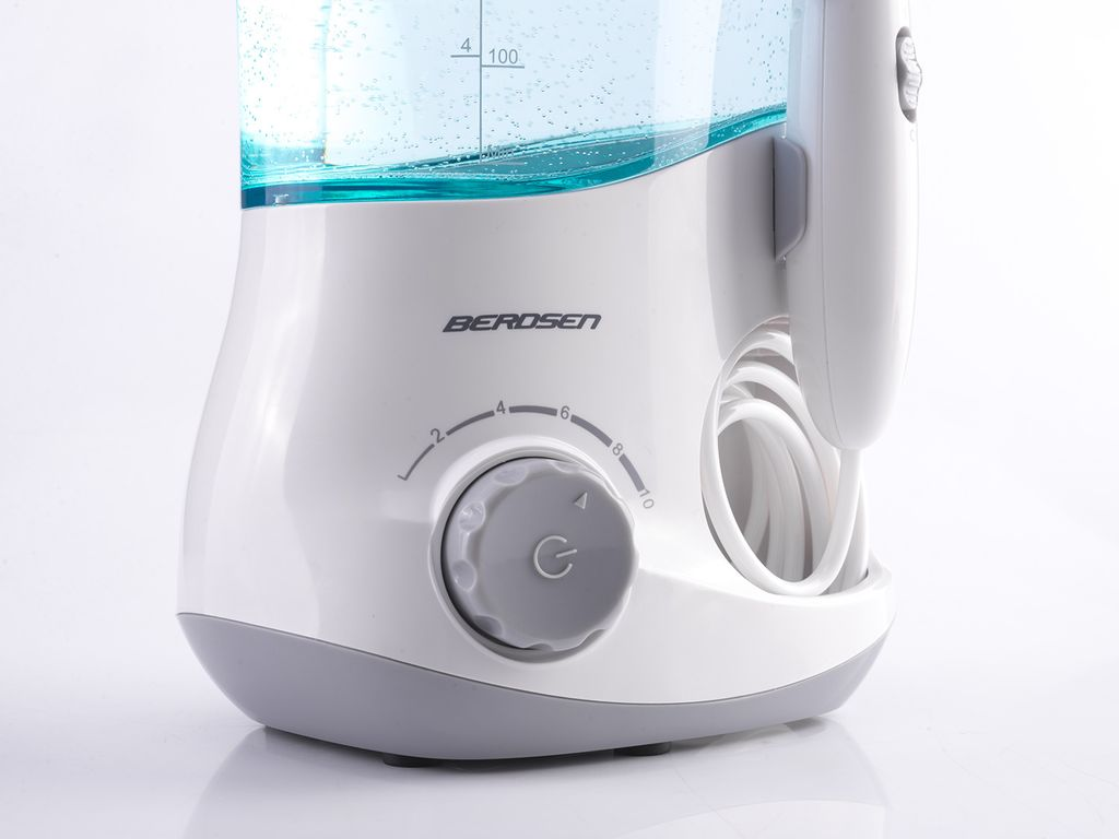 Eine weiße Berdsen Munddusche mit grauem Druckregler, Ein-Aus-Knopf und Wassertank oben.
