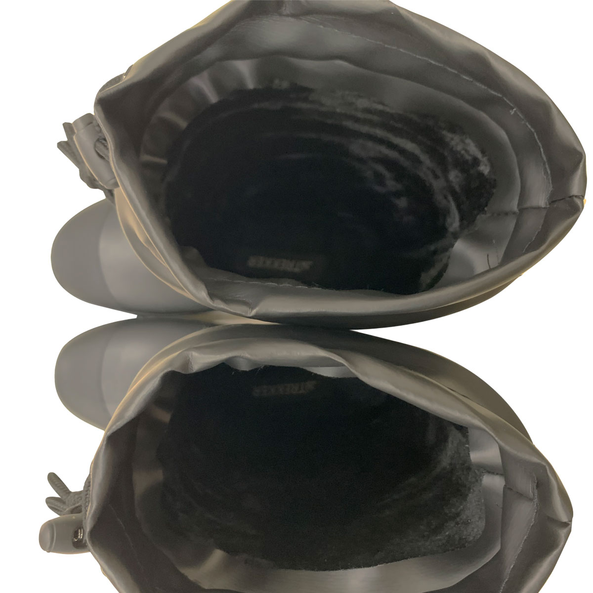 Top-down view of two black boots with warm inner lining.