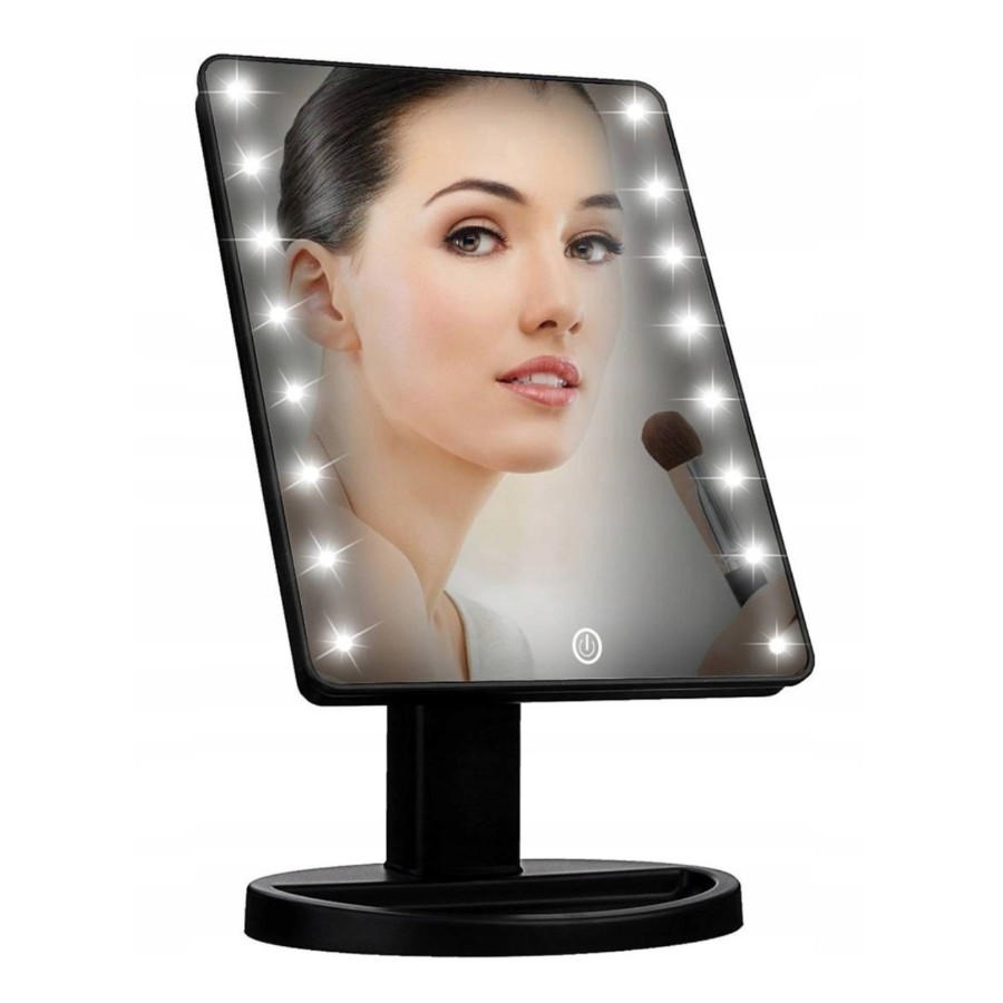 Uno specchio da trucco illuminato con cornice nera riflette il volto di una donna che si trucca.