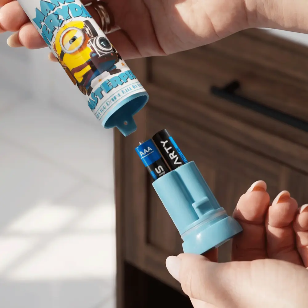Ręce otwierają niebieskie etui na baterie Minion z dwiema bateriami AAA.