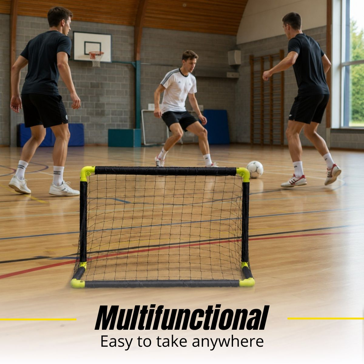 Three men play soccer in a gym, with a small goal in the foreground.