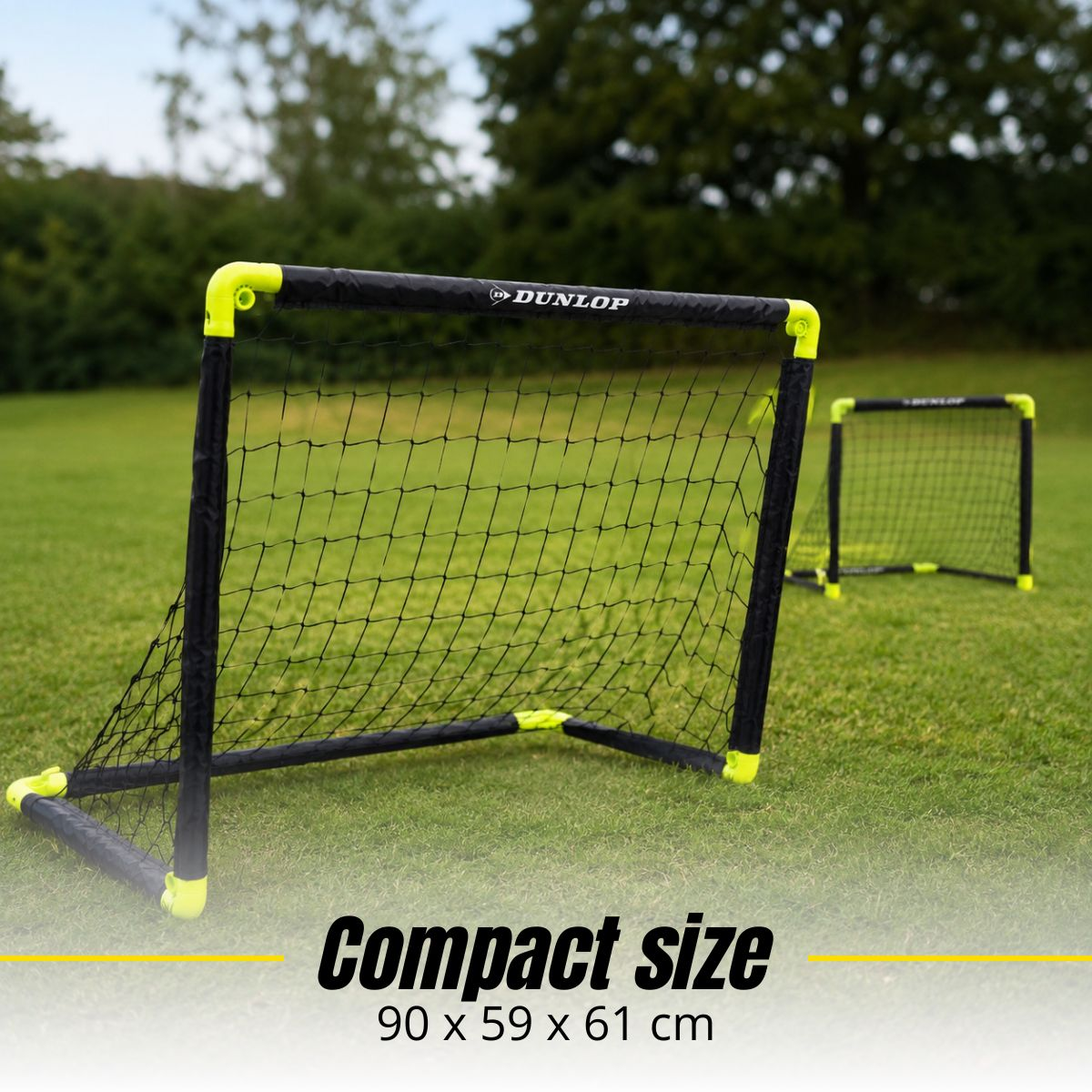 Two small Dunlop football goals stand on a green lawn. Dimensions 90x59x61 cm.