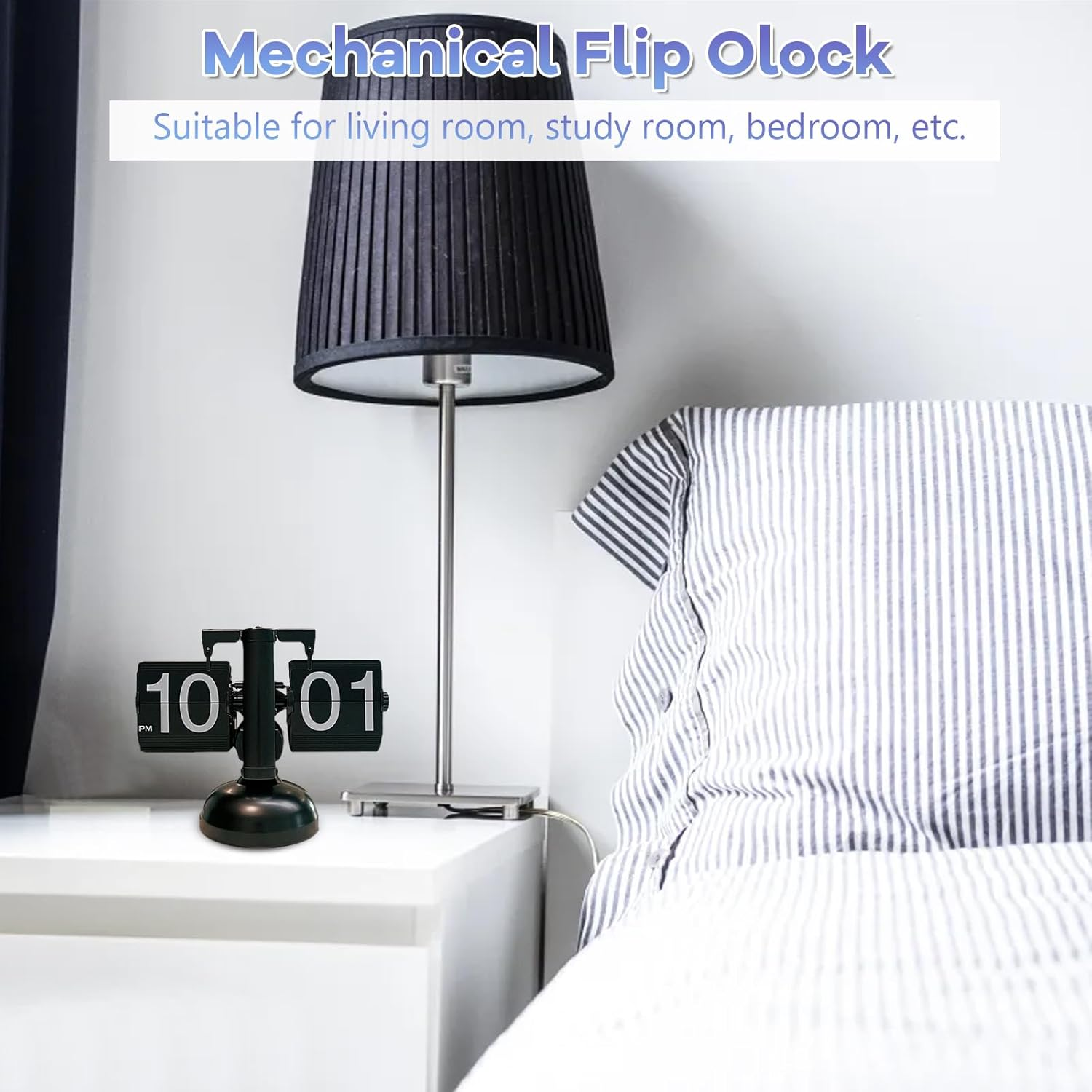Schwarze mechanische Flip-Uhr auf einem weißen Nachttisch neben einer Lampe und einem gestreiften Kissen.