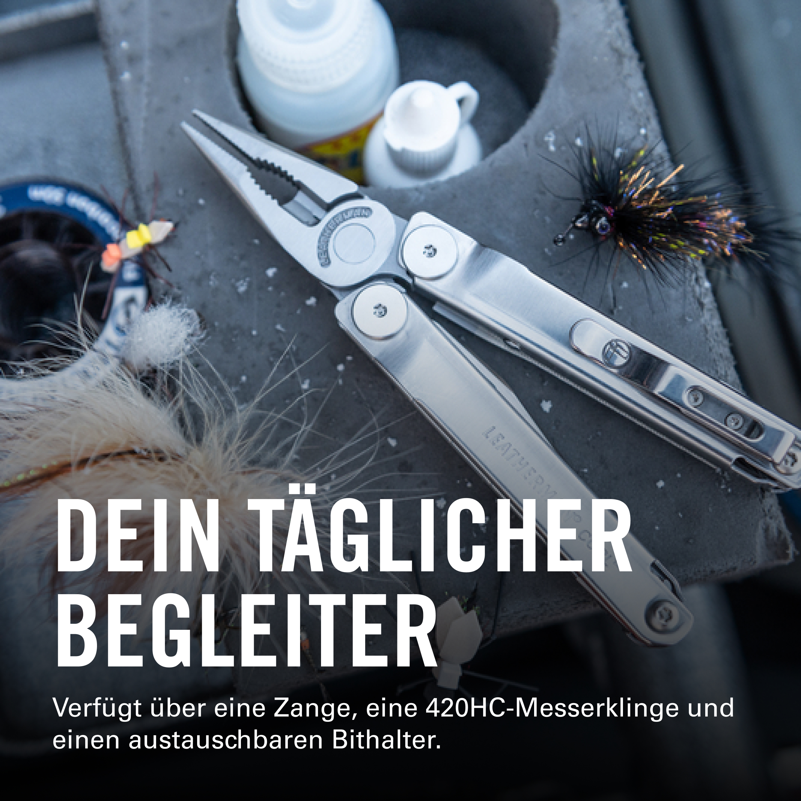 Eine silberne Zange und Angelutensilien liegen auf einem Stein.