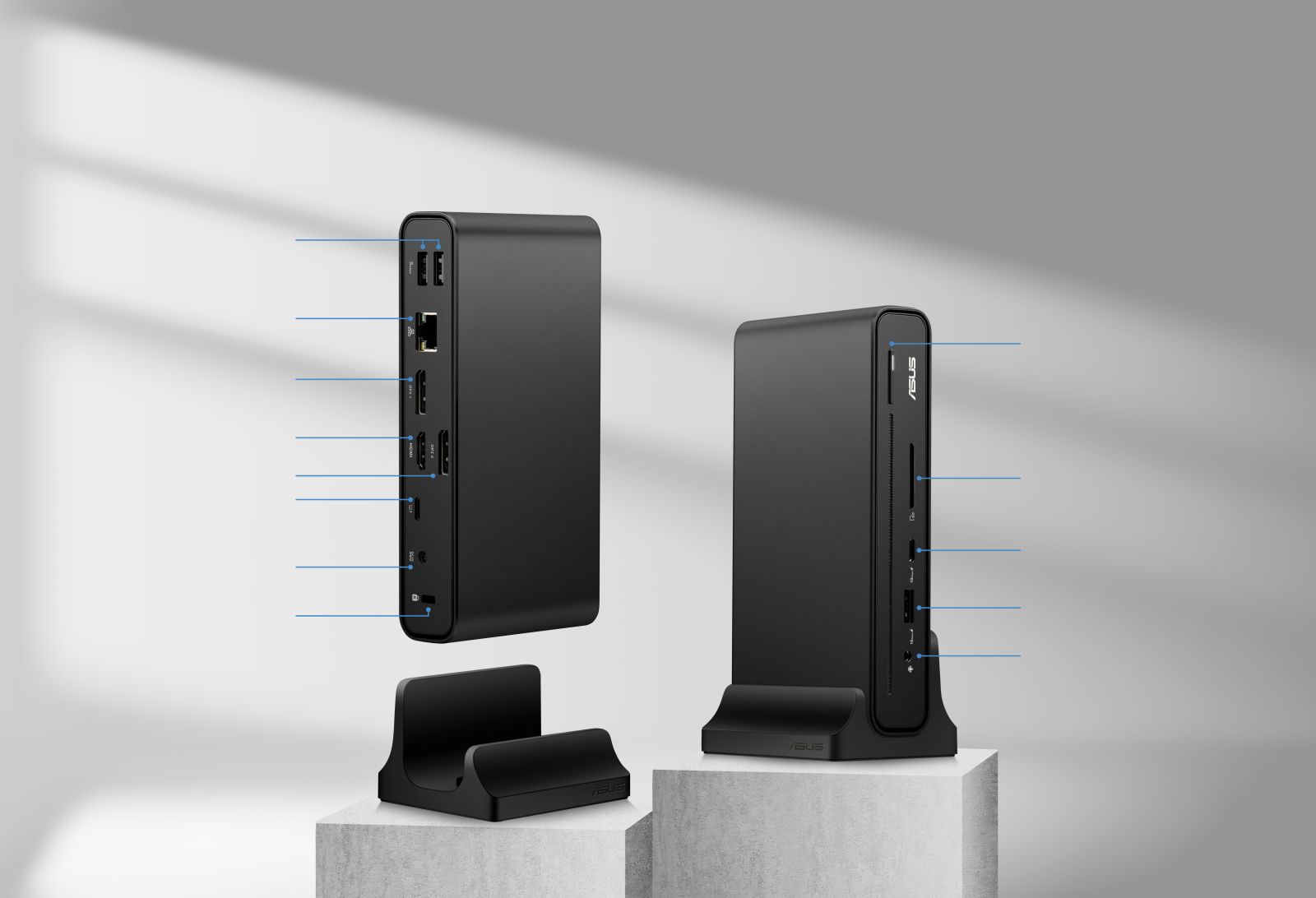 Due docking station ASUS nere su sfondo grigio, una su supporto che mostra le connessioni delle porte.