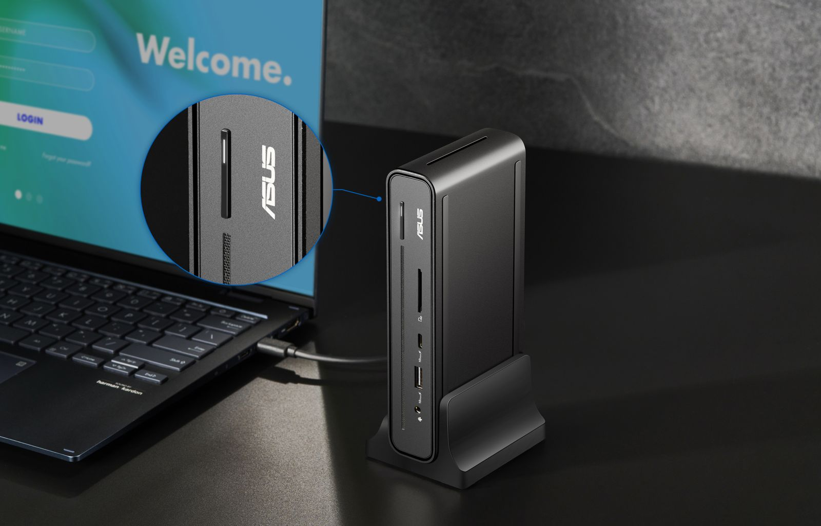 Un hub ASUS grigio accanto a un laptop con un dettaglio ingrandito delle porte.