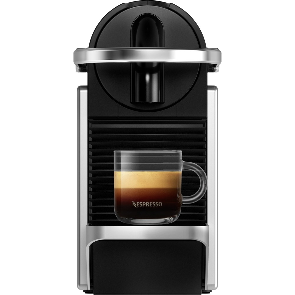 Damla tepsisinde kahve dolu cam kupası olan siyah ve gümüş renkli bir Nespresso kahve makinesi.
