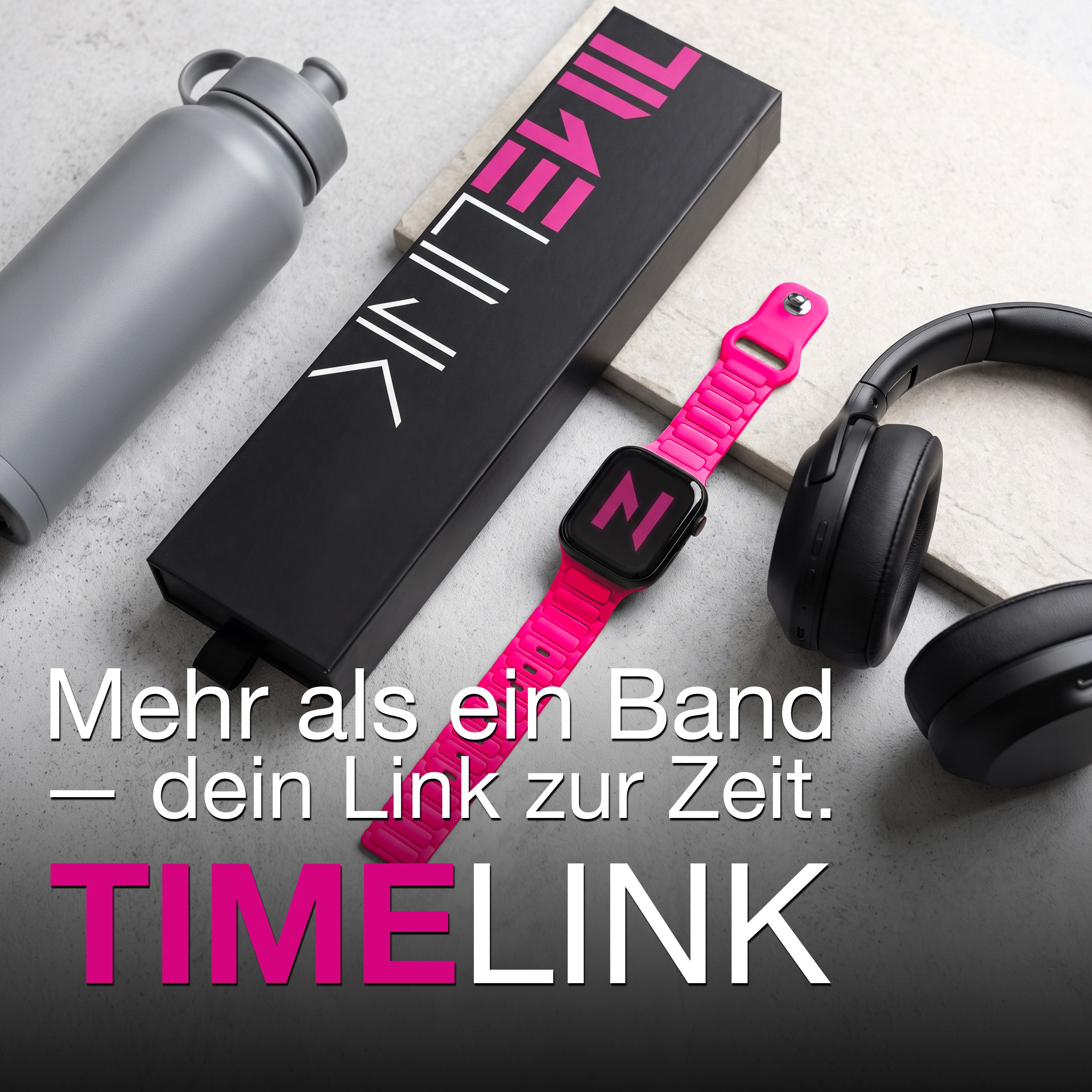 Graue Trinkflasche, schwarze Schachtel, pinke Smartwatch mit Armband und schwarze Kopfhörer auf hellem Grund.
