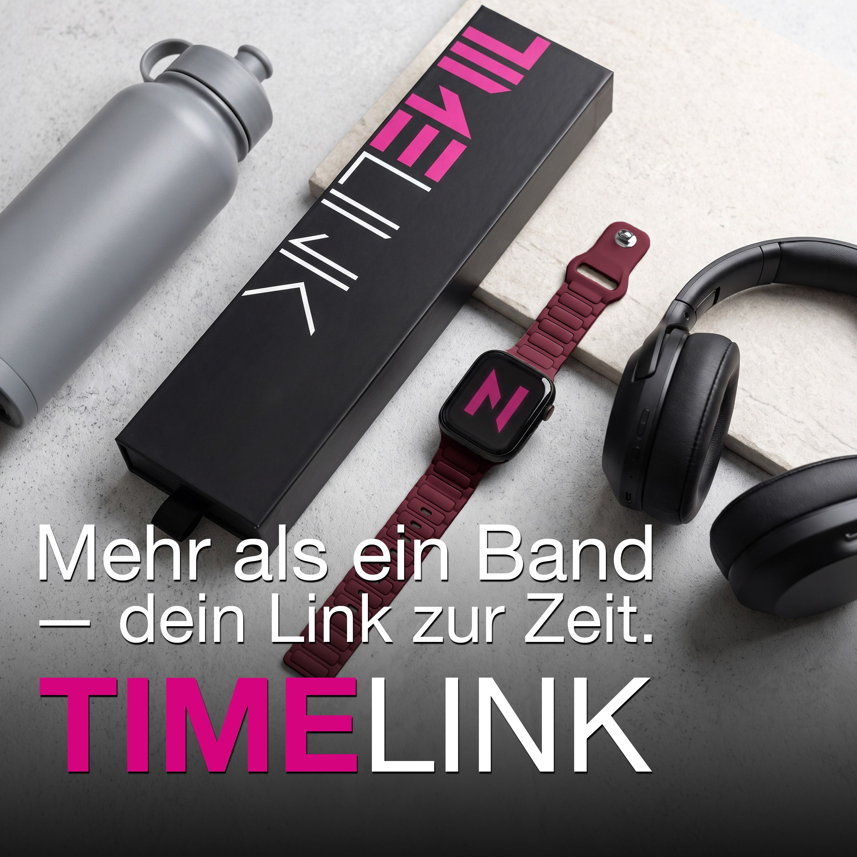 Eine graue Trinkflasche, eine schwarze Schachtel, eine Smartwatch mit bordeauxrotem Armband und schwarze Kopfhörer.