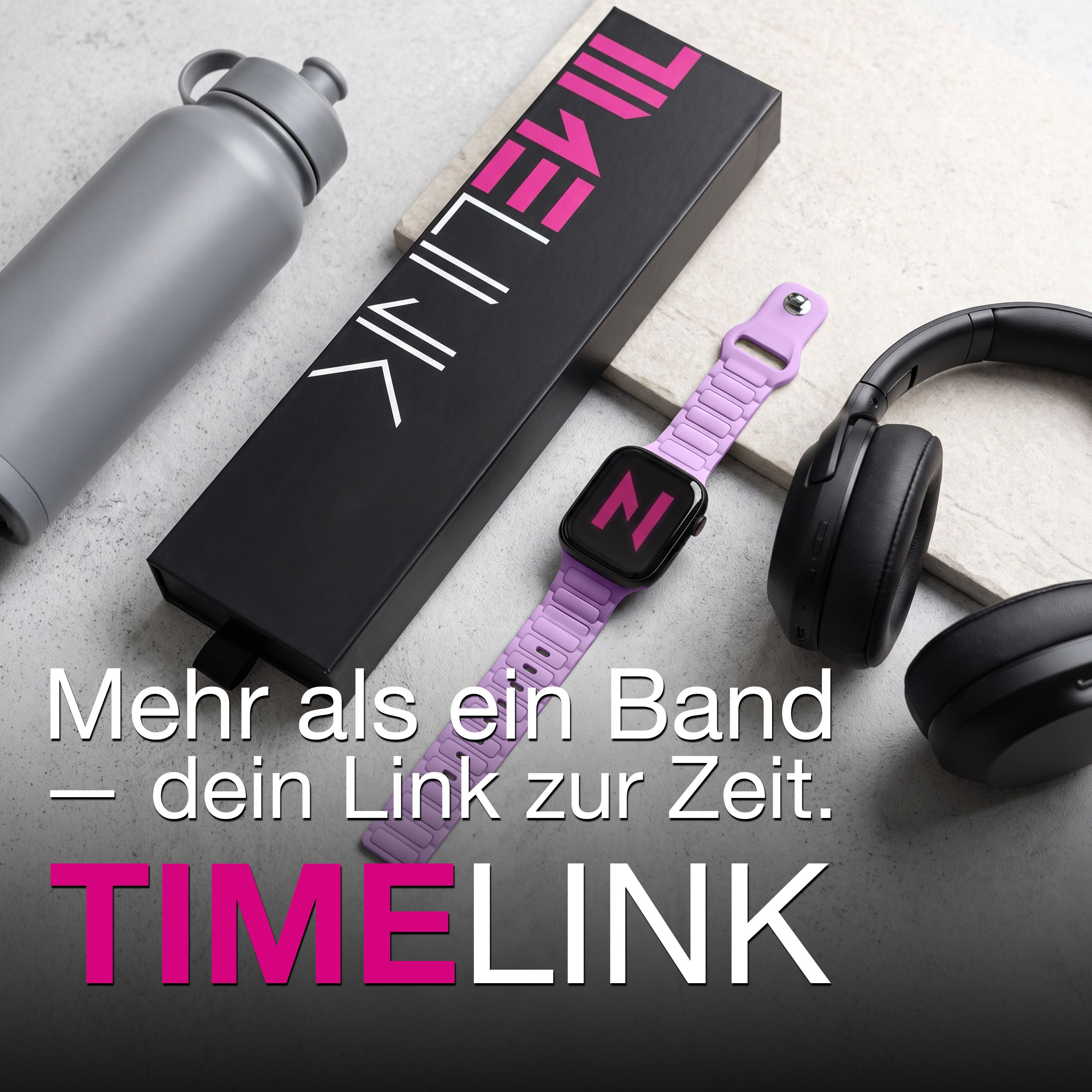 Eine graue Trinkflasche, eine schwarze Schachtel, eine lavendelfarbene Smartwatch und schwarze Kopfhörer.