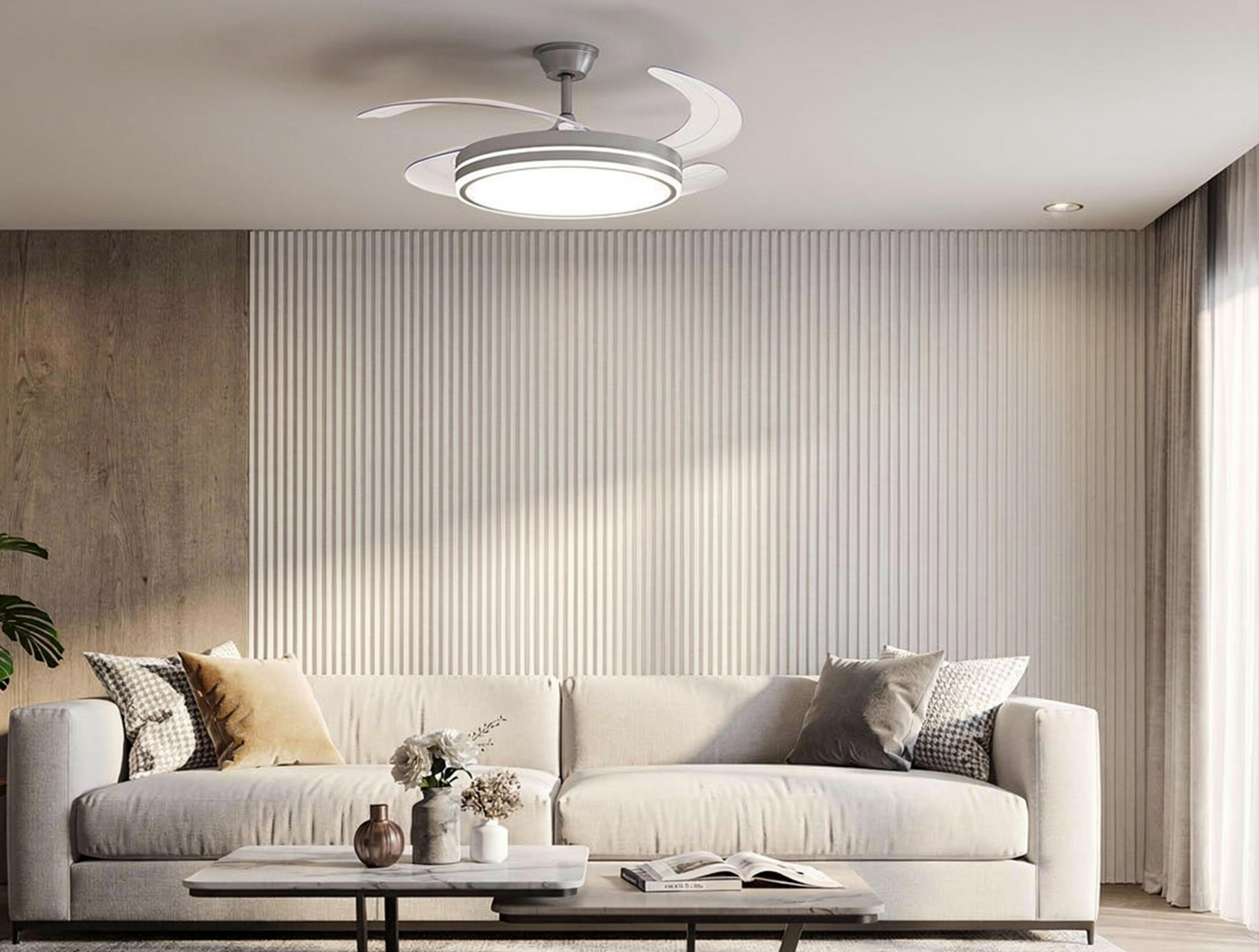 Una sala de estar tiene un sofá blanco, un ventilador de techo moderno y una pared de listones.