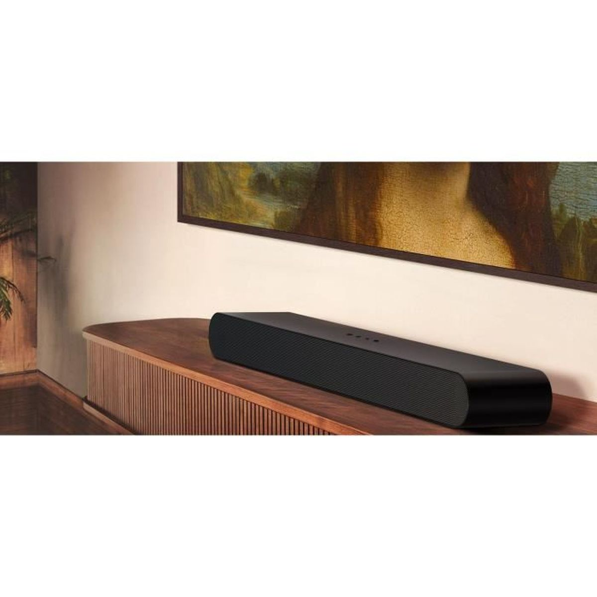 Una soundbar nera poggia su un mobile TV in legno contro una parete beige con un dipinto.