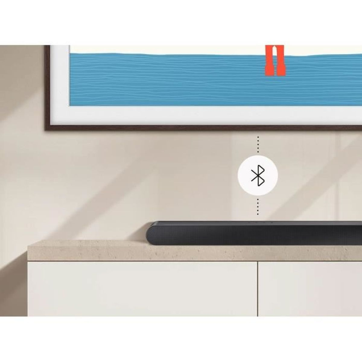 Una soundbar su un mobile con un'icona Bluetooth e un quadro alla parete.