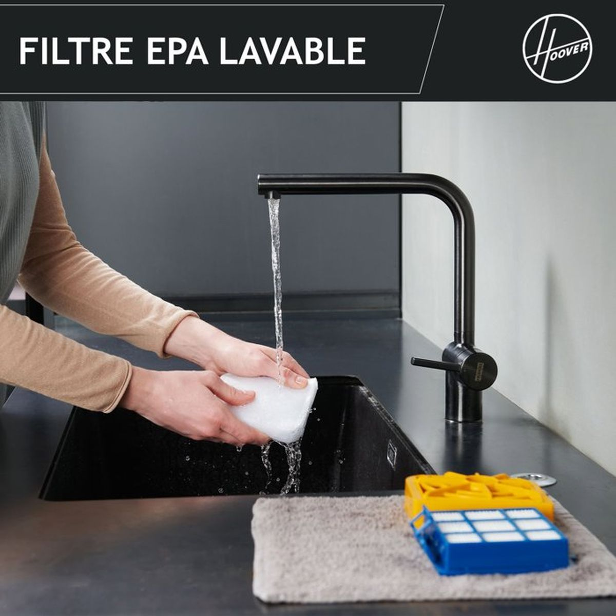 Qualcuno lava un filtro bianco sotto un moderno rubinetto nero in una cucina buia.