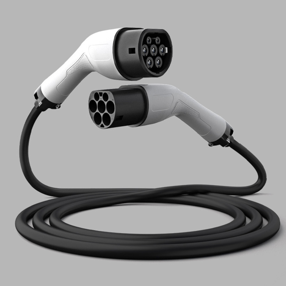 Zwei weiße und schwarze Elektrofahrzeug-Ladekabel mit Steckern liegen vor einem grauen Hintergrund.