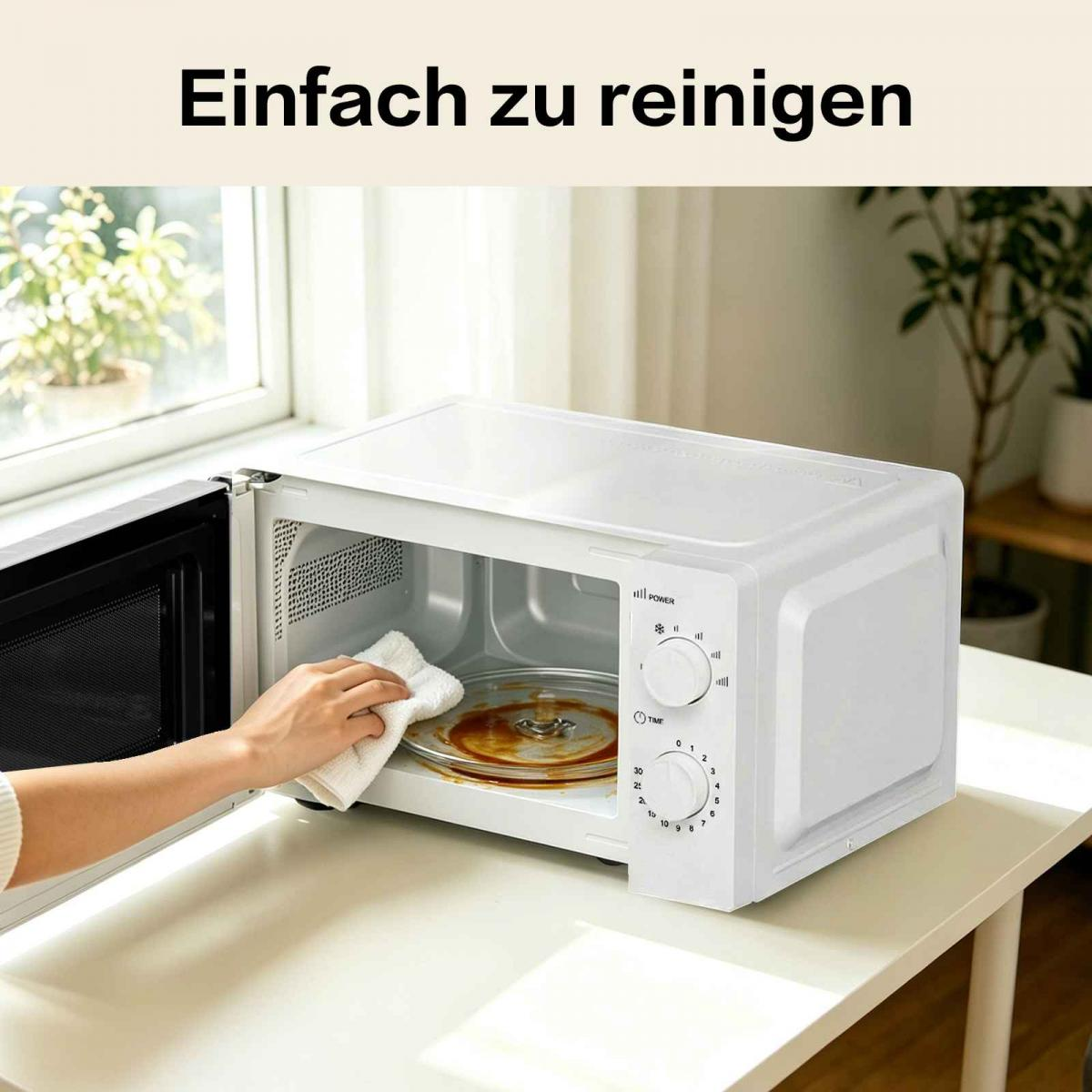 Eine Hand wischt mit einem Tuch den Innenraum einer weißen Mikrowelle.