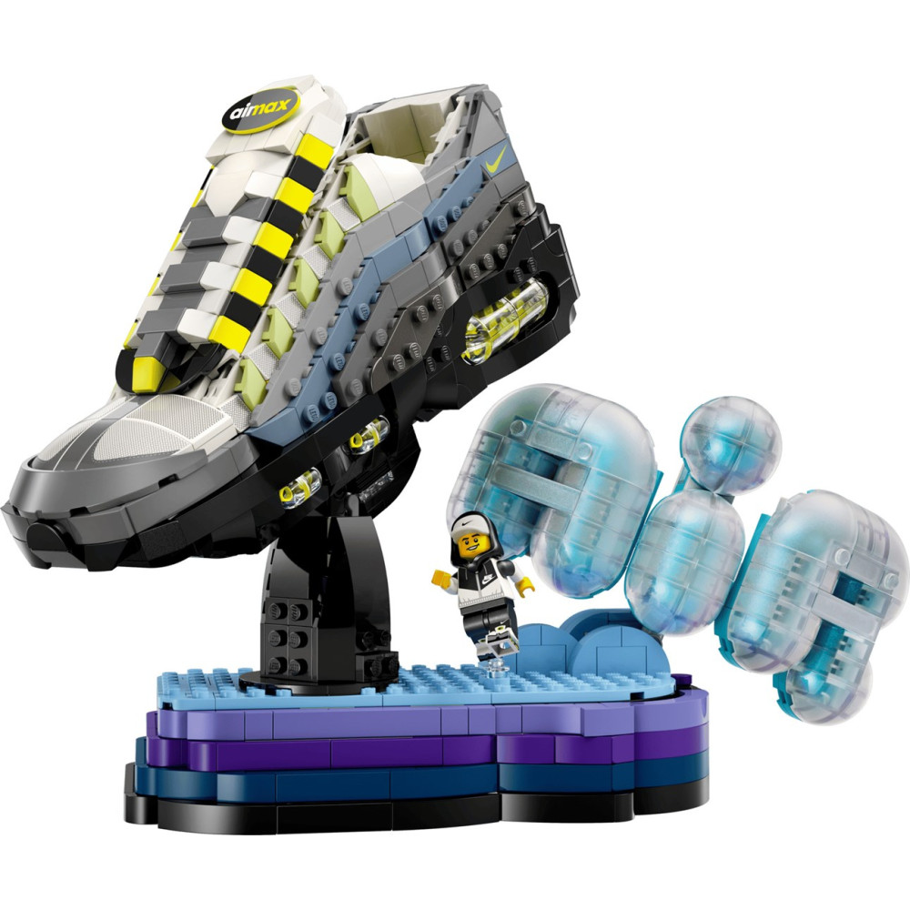Model Lego przedstawiający tenisówkę na stojaku z minifigurką i niebieskimi bąbelkami.