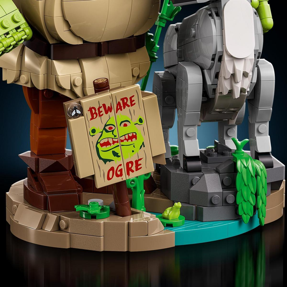 Figura Lego z szyldem z napisem Beware Ogre, obok szarego zwierzęcia.
