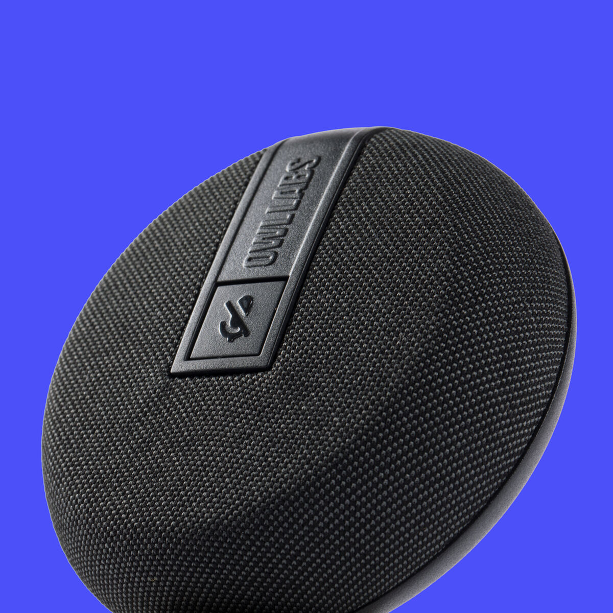 Altoparlante rotondo nero con logo integrato e rivestimento in tessuto su sfondo blu.