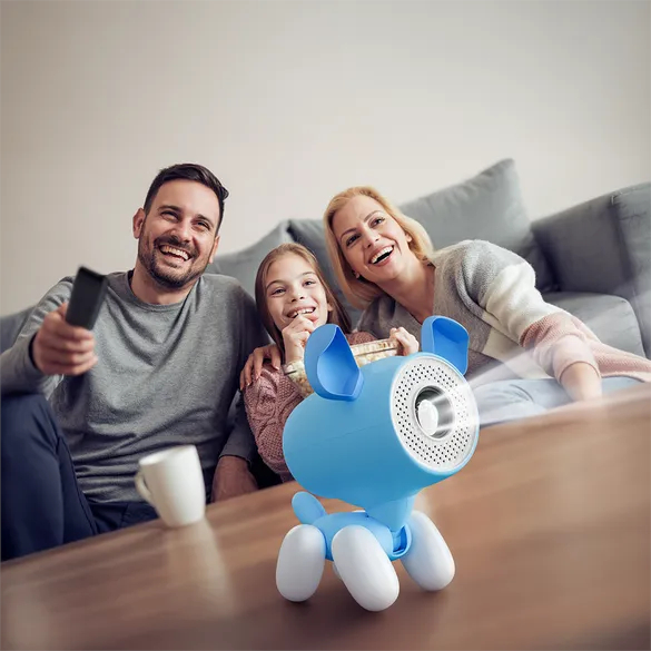 Una famiglia felice guarda un film proiettato da un proiettore blu a forma di cane su un tavolino.