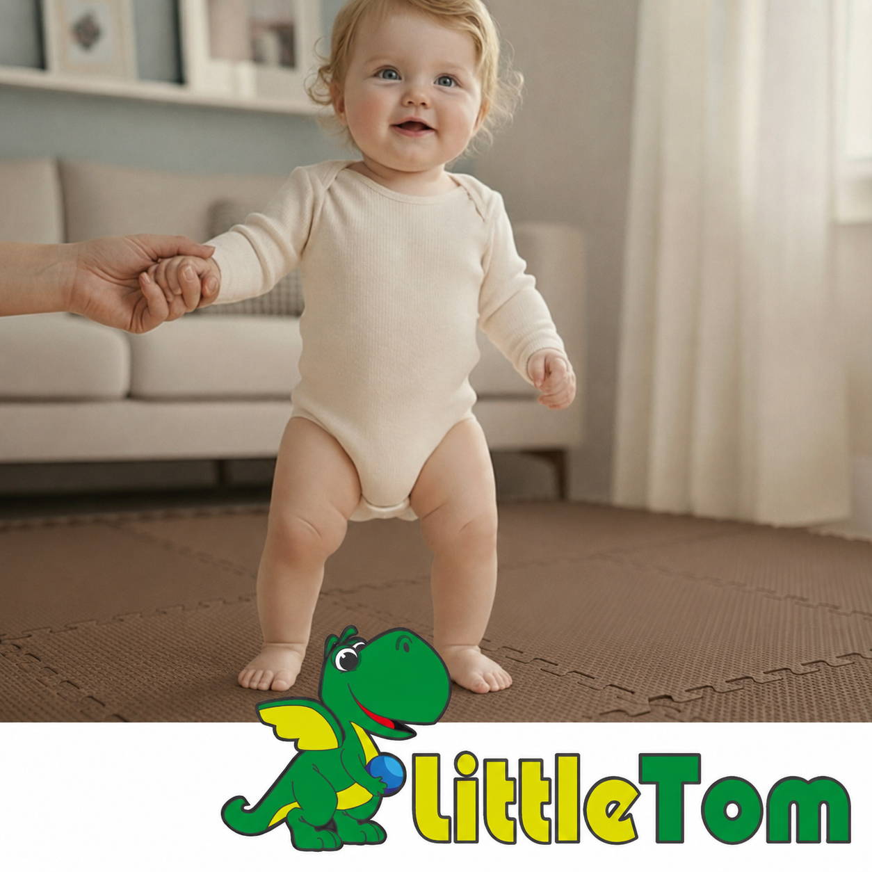 Baby in beigeem Body hält an Hand eines Erwachsenen, im Hintergrund ein Sofa und LittleTom-Logo.