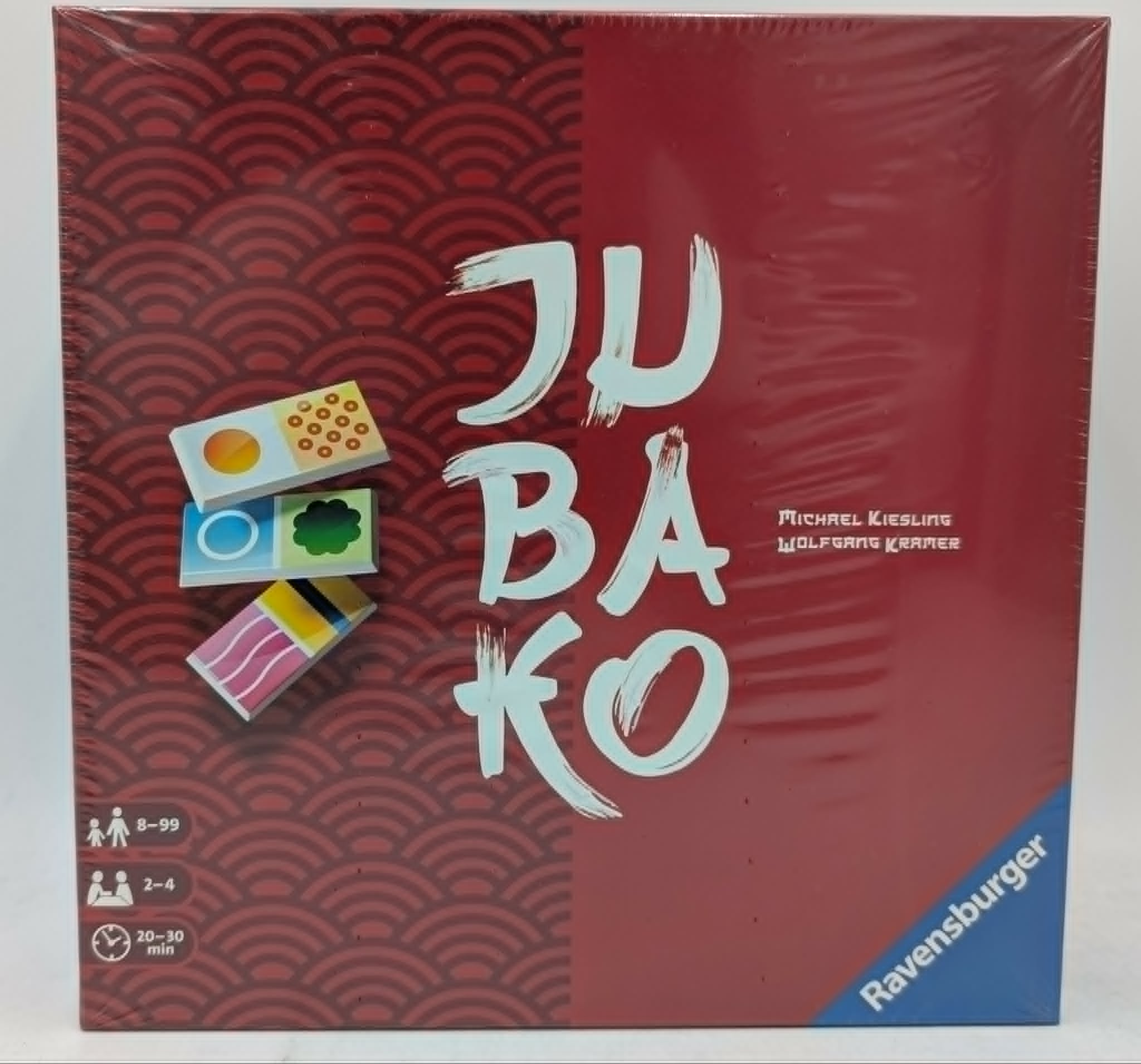 Spielschachtel von JUBAKO auf rotem Mustergrund, Ravensburger Logo.