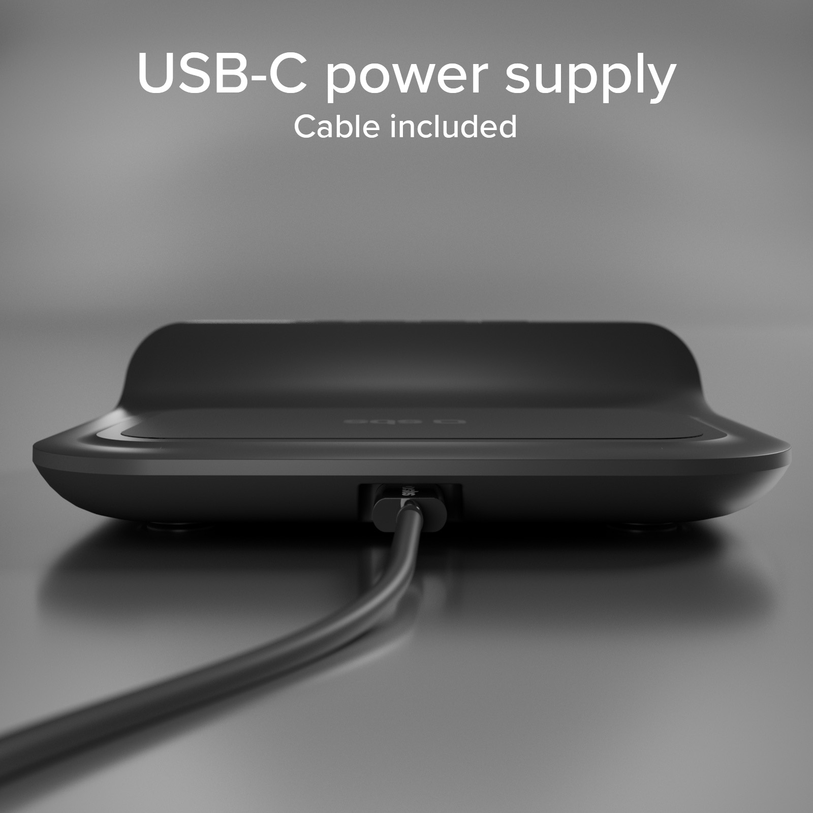 Base de carga inalambrica negra con cable USB-C conectado sobre fondo gris.