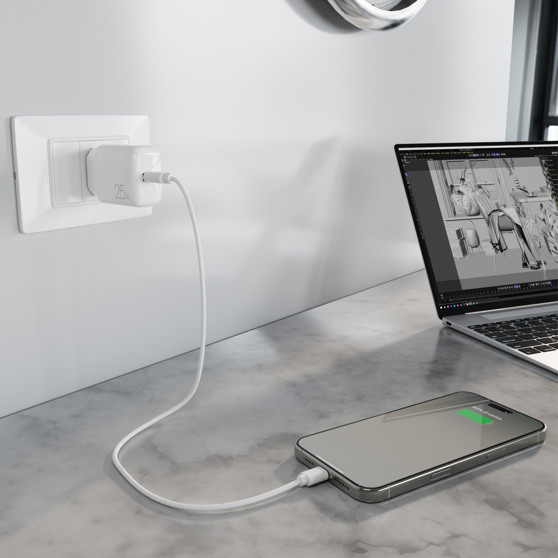 Un smartphone se carga en una mesa de mármol, conectado a un cargador de pared. A la derecha hay un portátil.