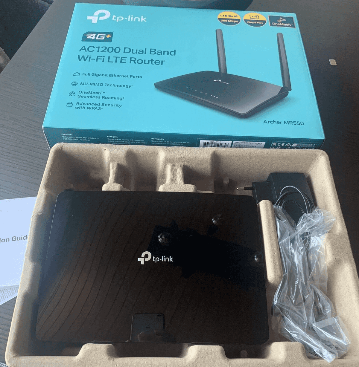 Router Wi-Fi LTE TP-Link AC1200 en embalaje abierto con accesorios.