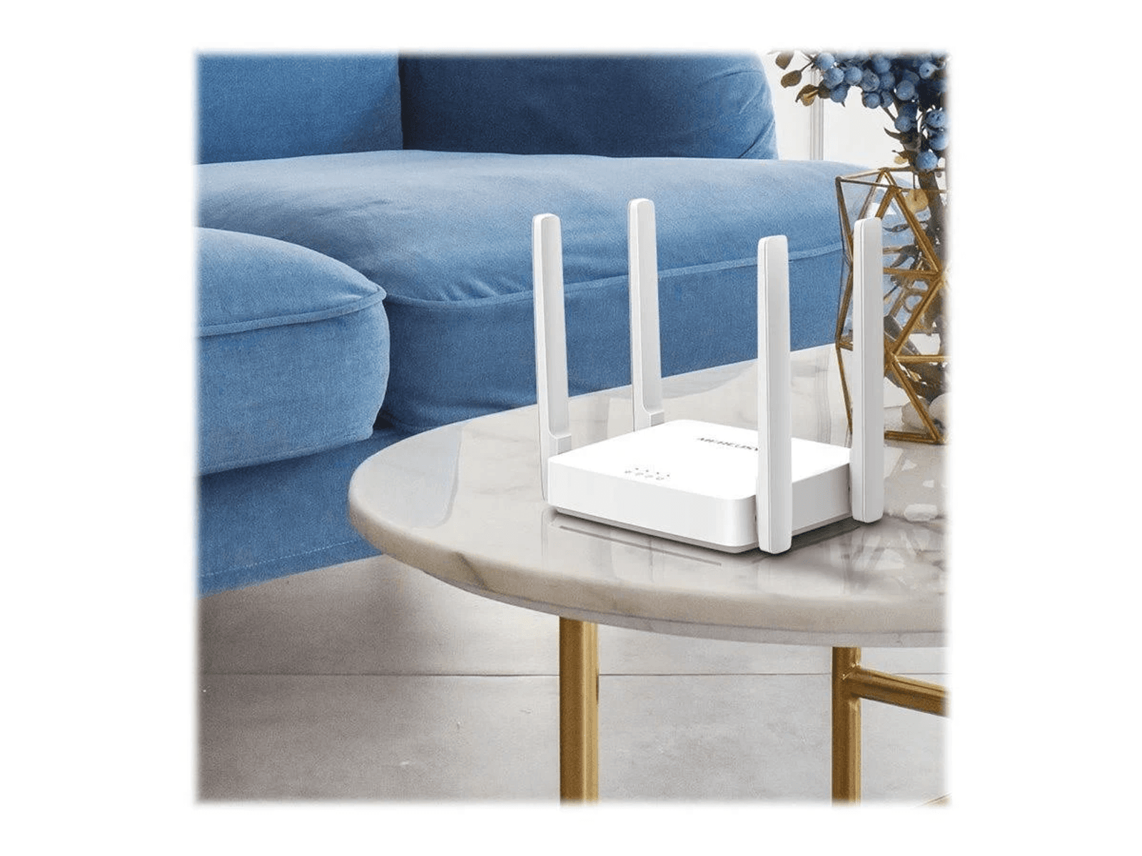 Un router Wi-Fi bianco con quattro antenne si trova su un tavolo rotondo di marmo davanti a un divano blu.