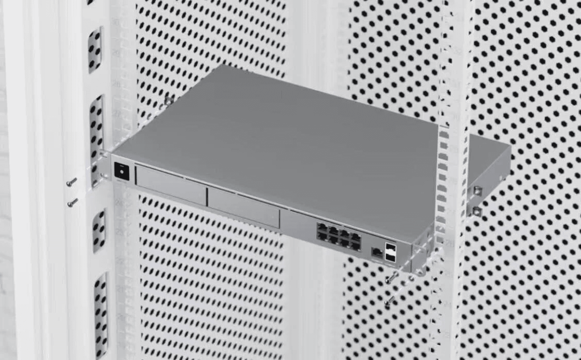 Un dispositivo di rete montato in un rack metallico perforato.