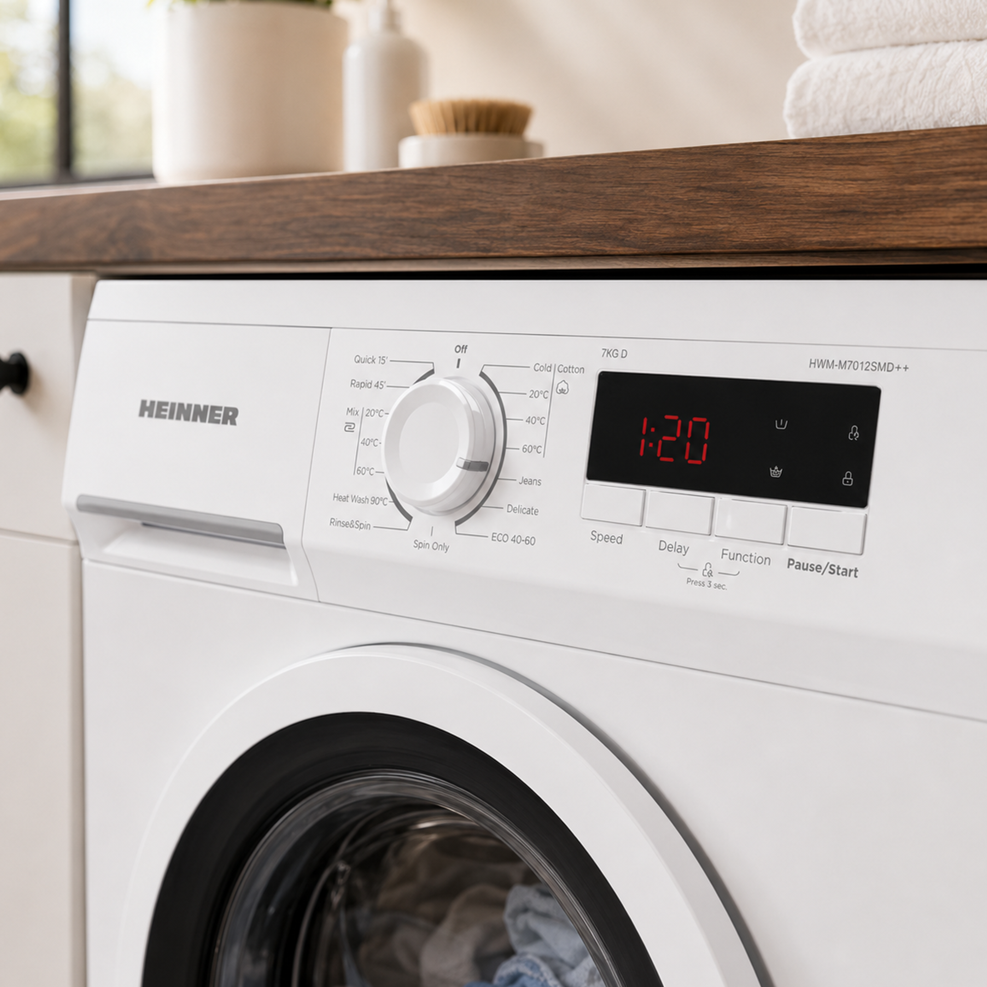 Close-up van een witte Heinner wasmachine met digitaal display en bedieningspaneel.