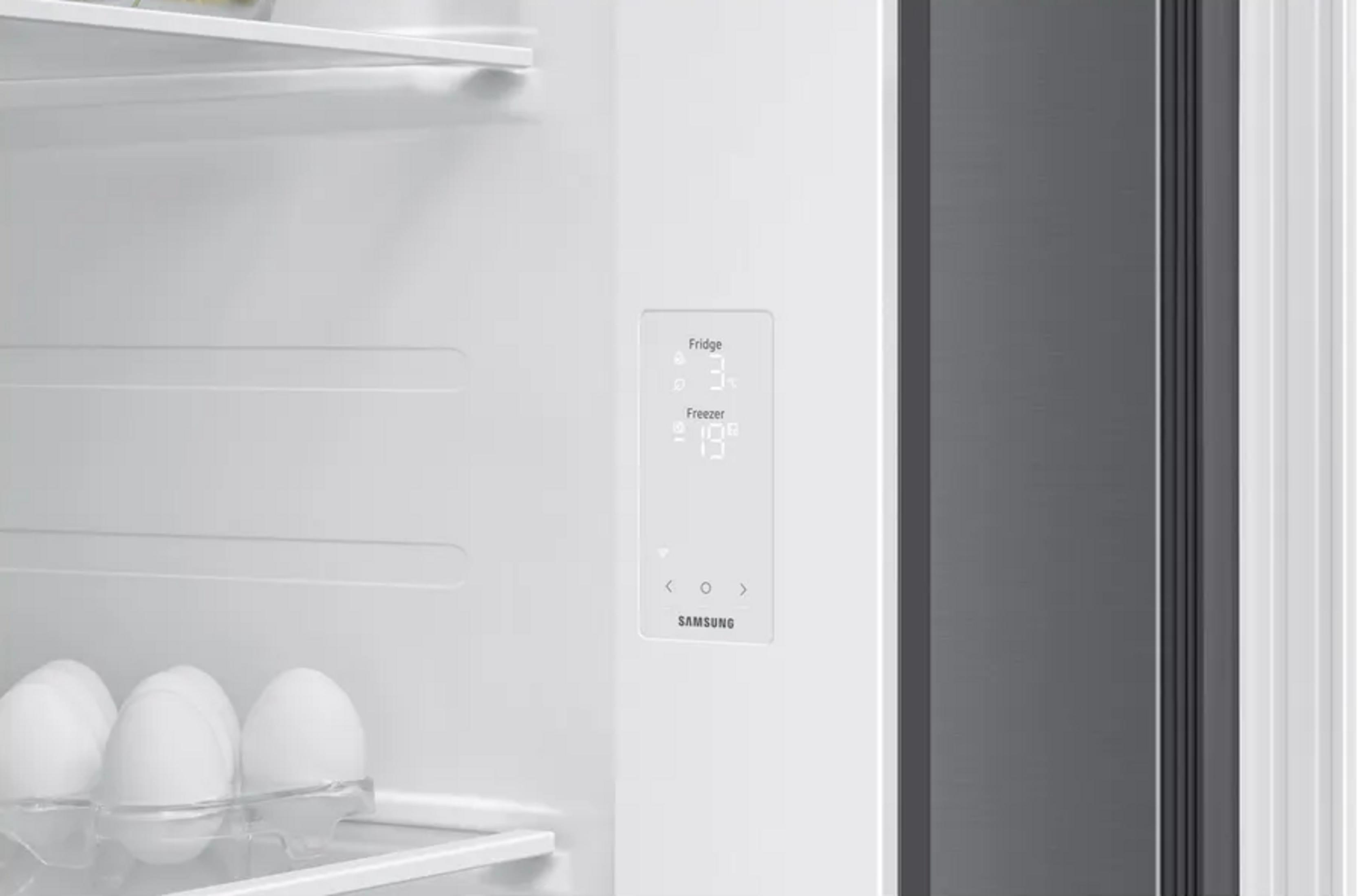 Interno di un frigorifero bianco con pannello di controllo a LED, display della temperatura e portauova.