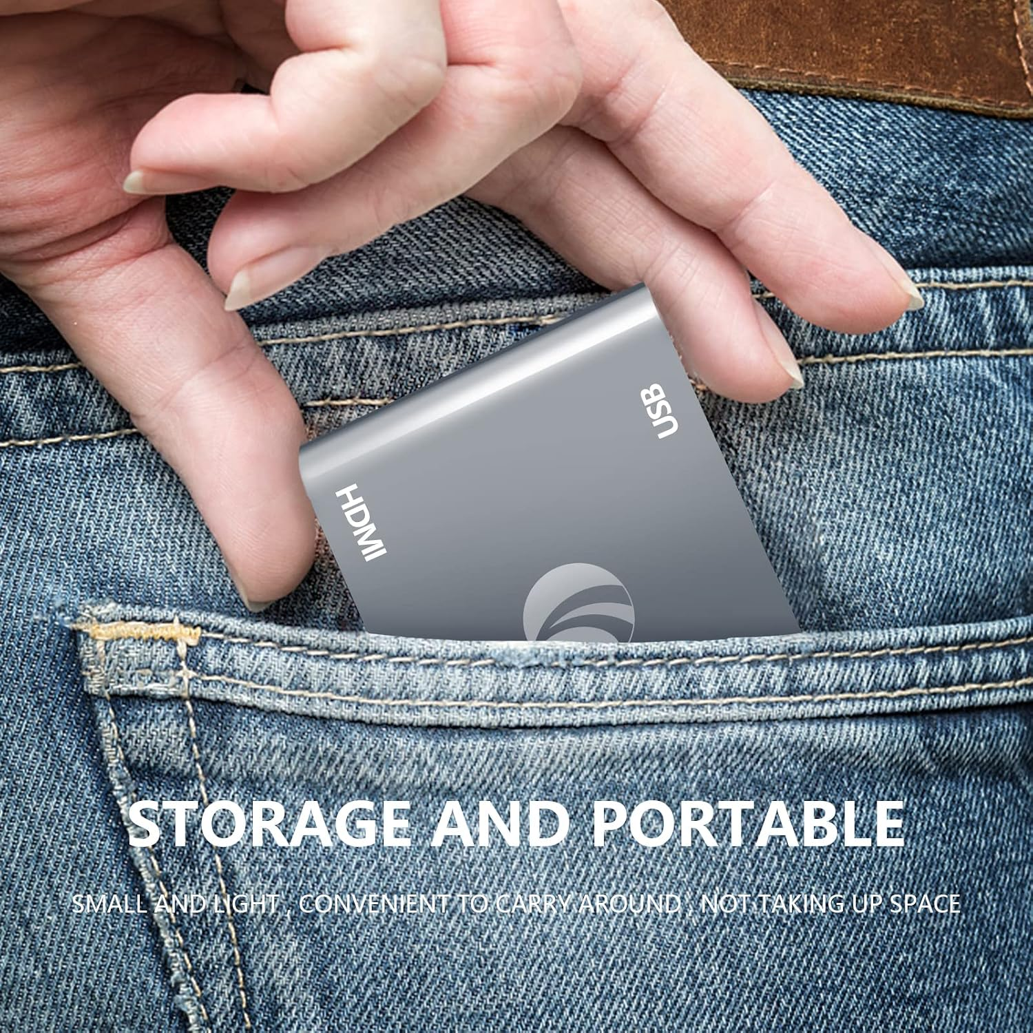 Eine Hand steckt einen grauen USB- und HDMI-Adapter in eine blaue Jeanshose.