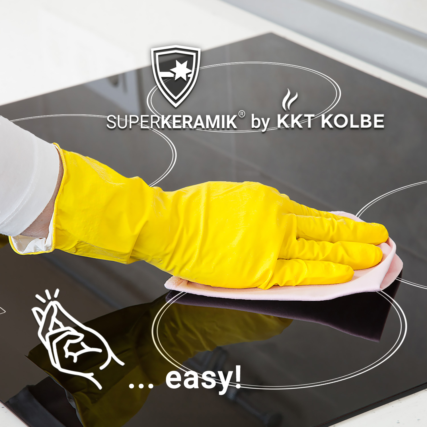 Una mano con guanto giallo pulisce un piano cottura nero con un panno, con la scritta SUPERKERAMIK.