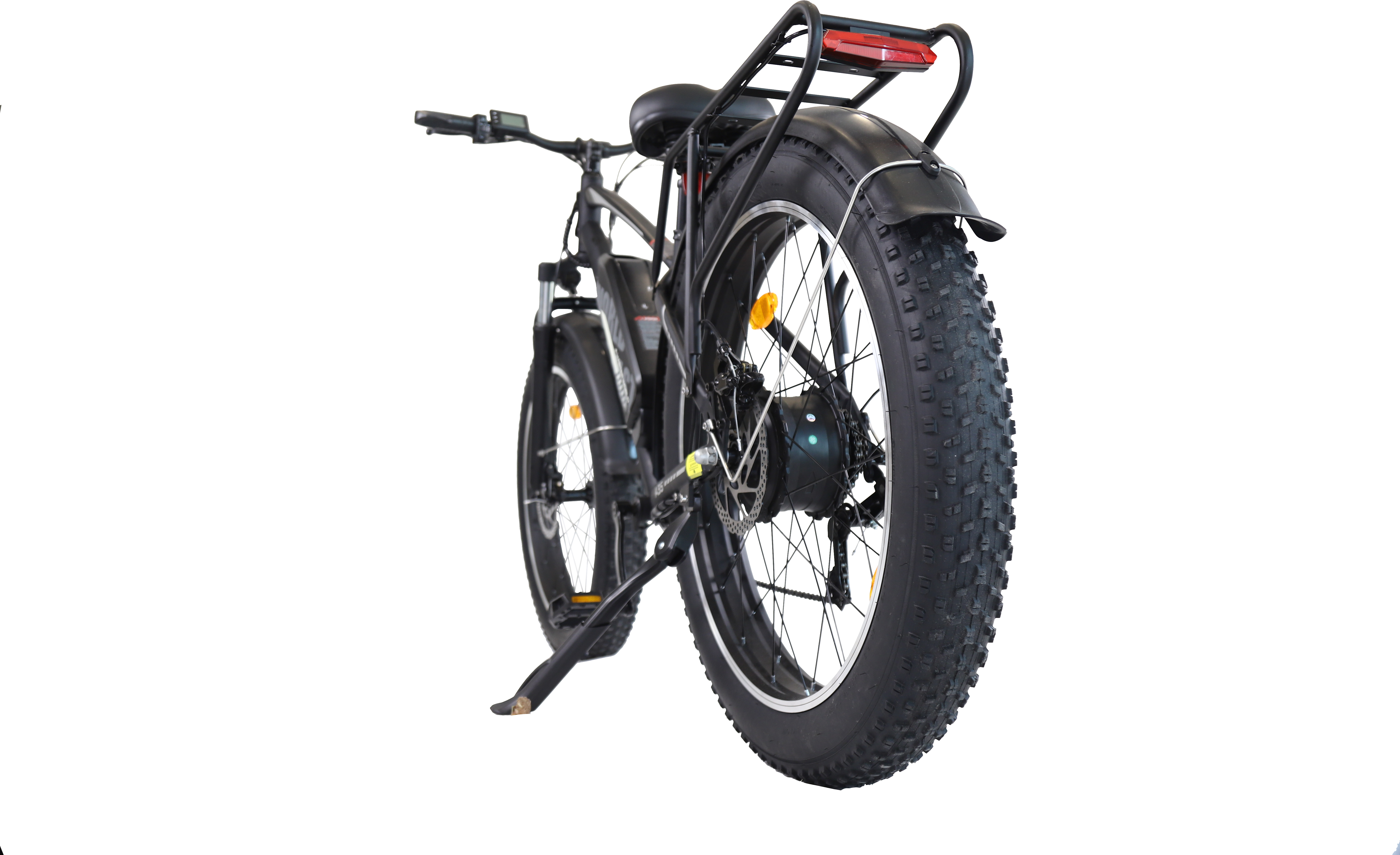 Una e-bike nera con pneumatici larghi, portapacchi e freni a disco isolata su sfondo nero.
