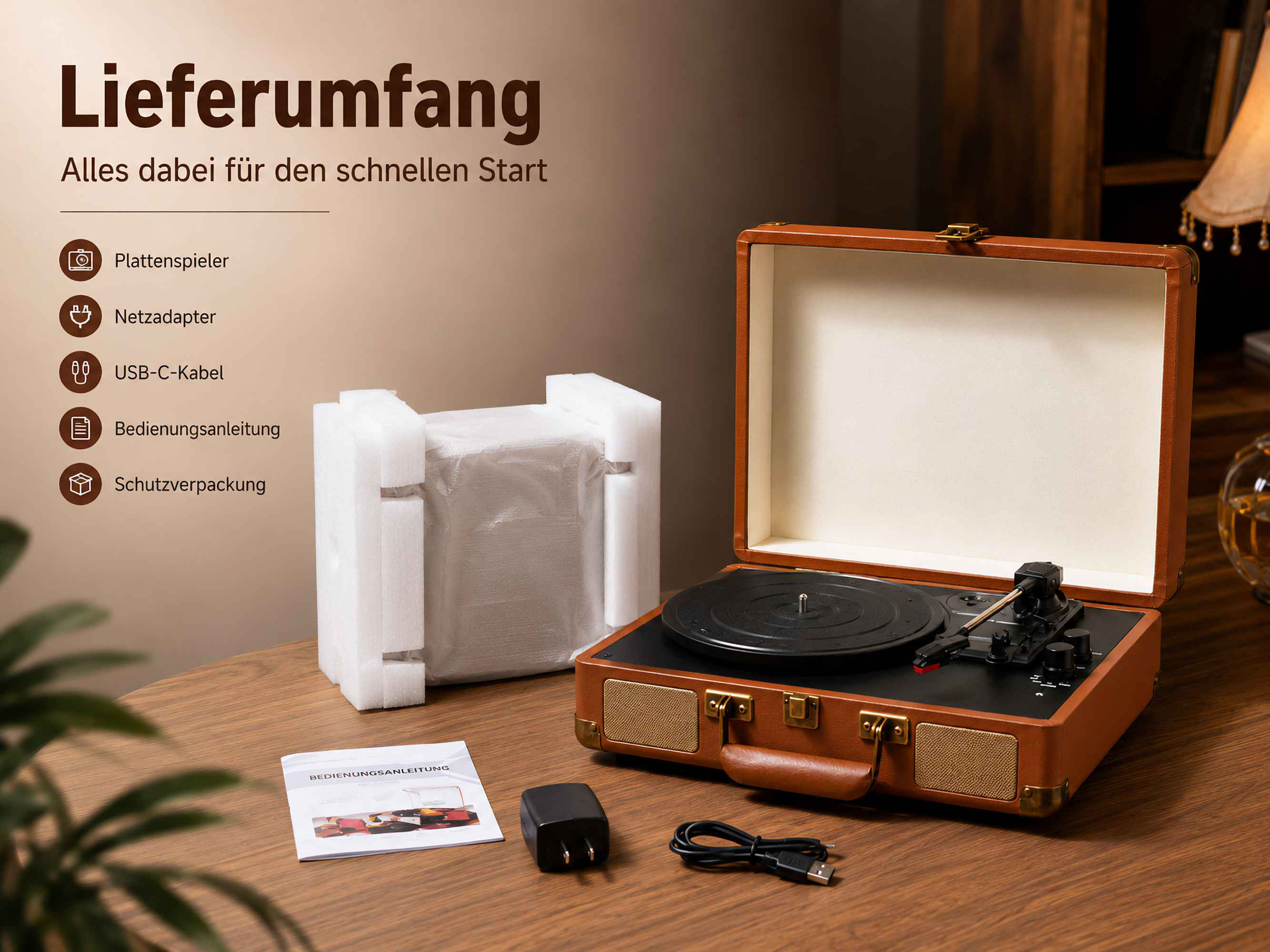 Lieferumfang mit Plattenspieler im braunen Koffer, Anleitung, Netzteil, USB-Kabel und Verpackung auf Holztisch.