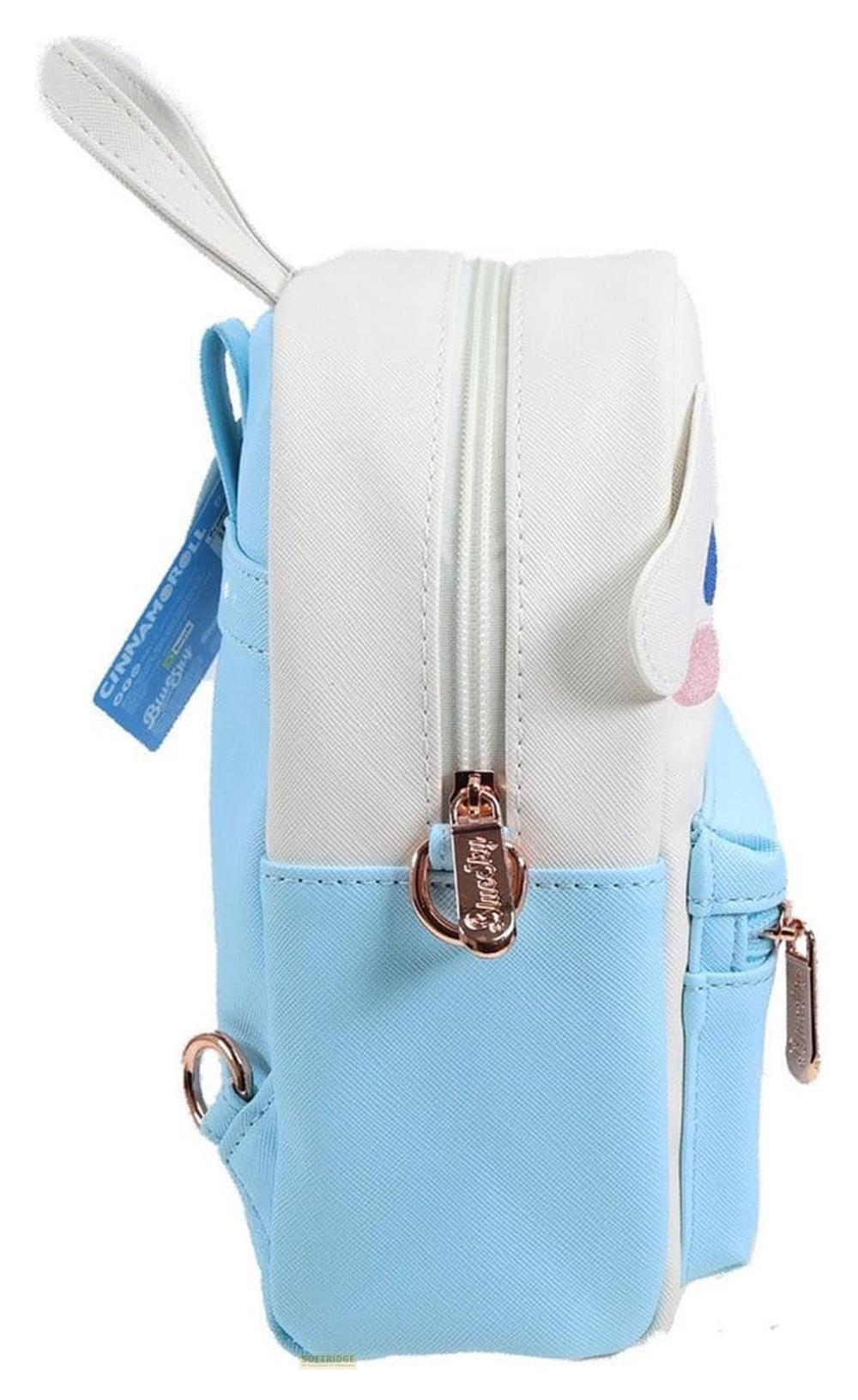 Seitenansicht eines hellblauen und weißen Mini-Rucksacks mit rosegoldenen Reißverschlüssen und einem blauen Etikett.