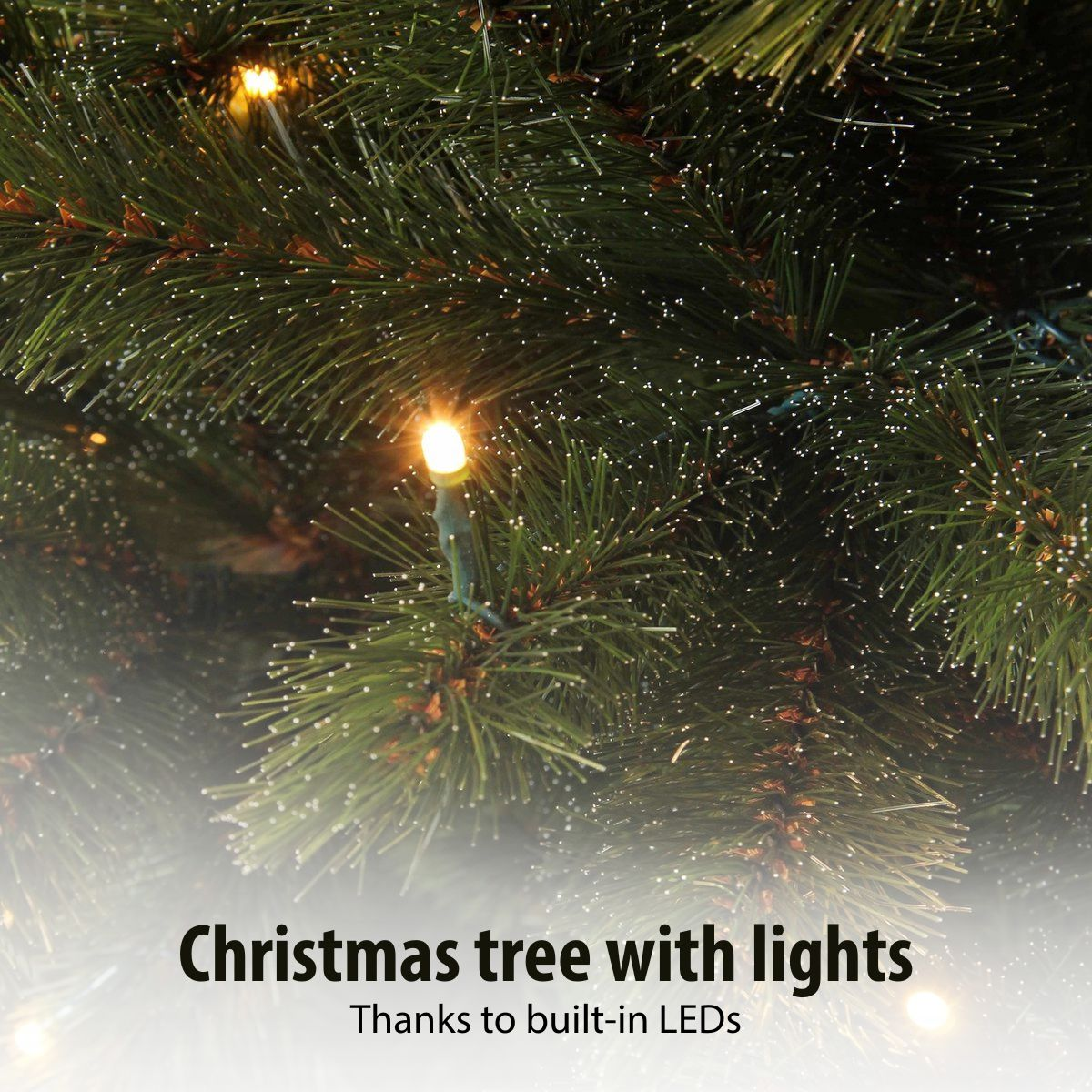 Close-up of green Christmas tree branches decorated with glowing warm white LED lights and frosted tips.