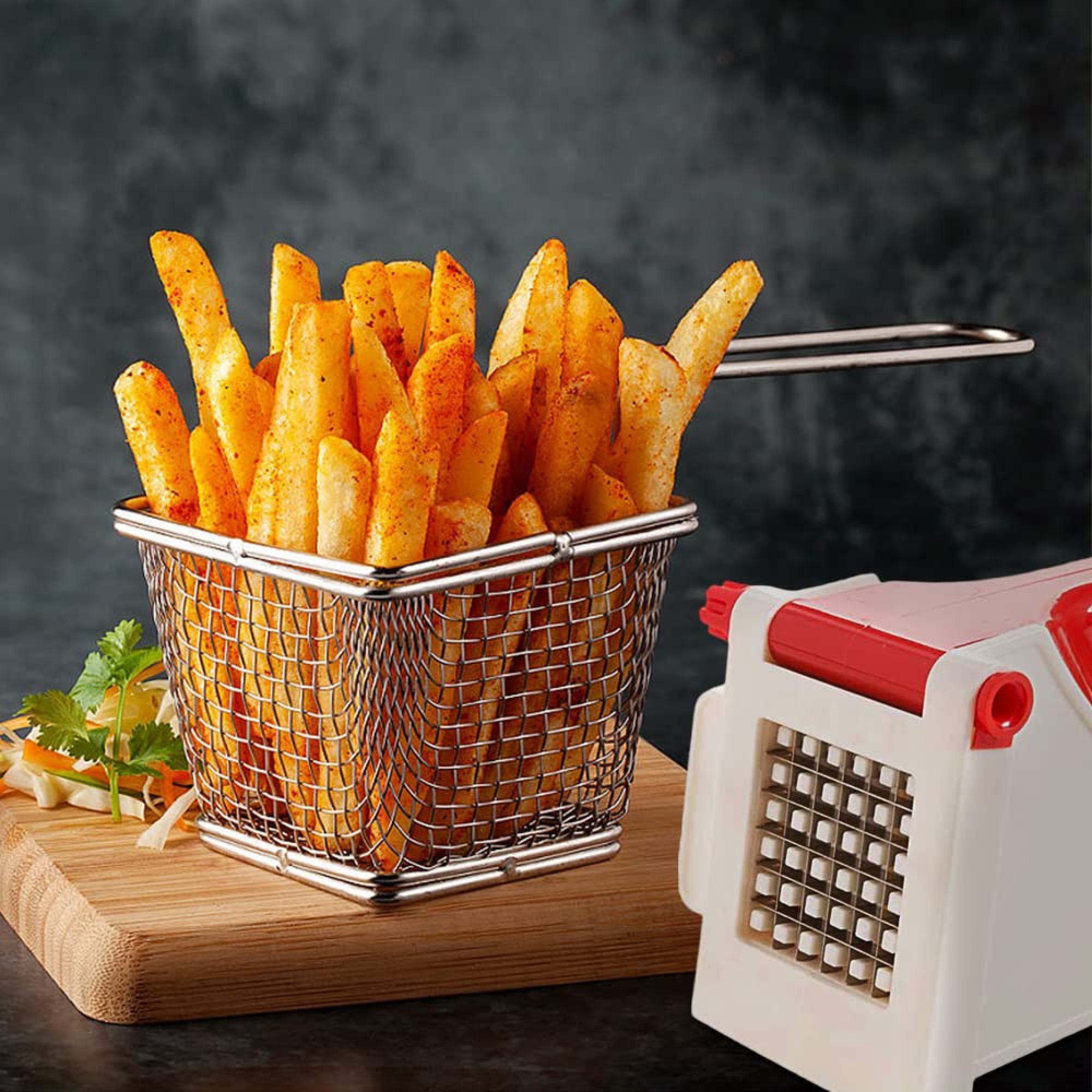 Goldbraune Pommes in einem Metallkorb auf einem Holzbrett neben einem Gemüseschneider.
