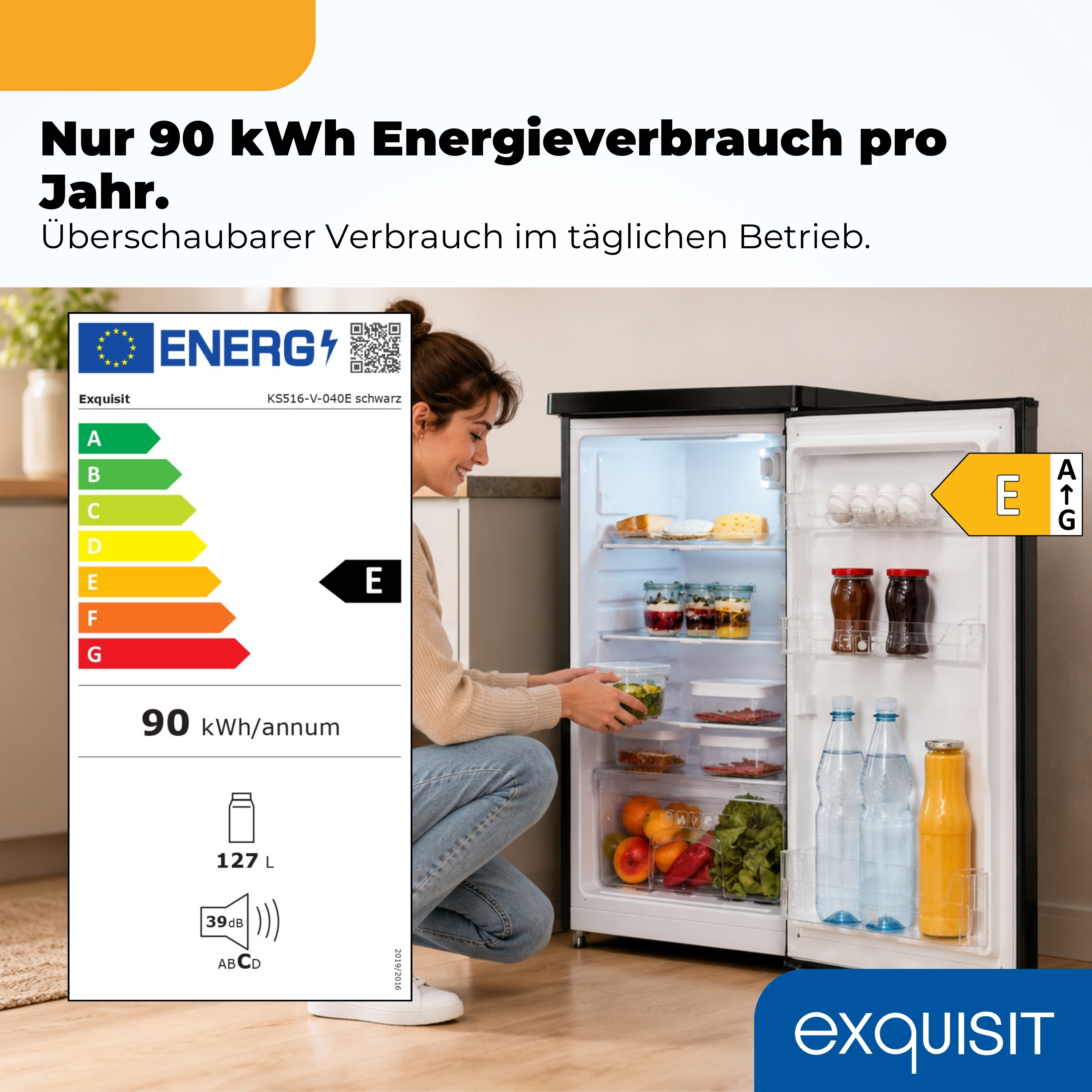 Eine Frau blickt in einen offenen Exquisit Kühlschrank mit Energieeffizienzklasse E und 90 kWh Jahresverbrauch.