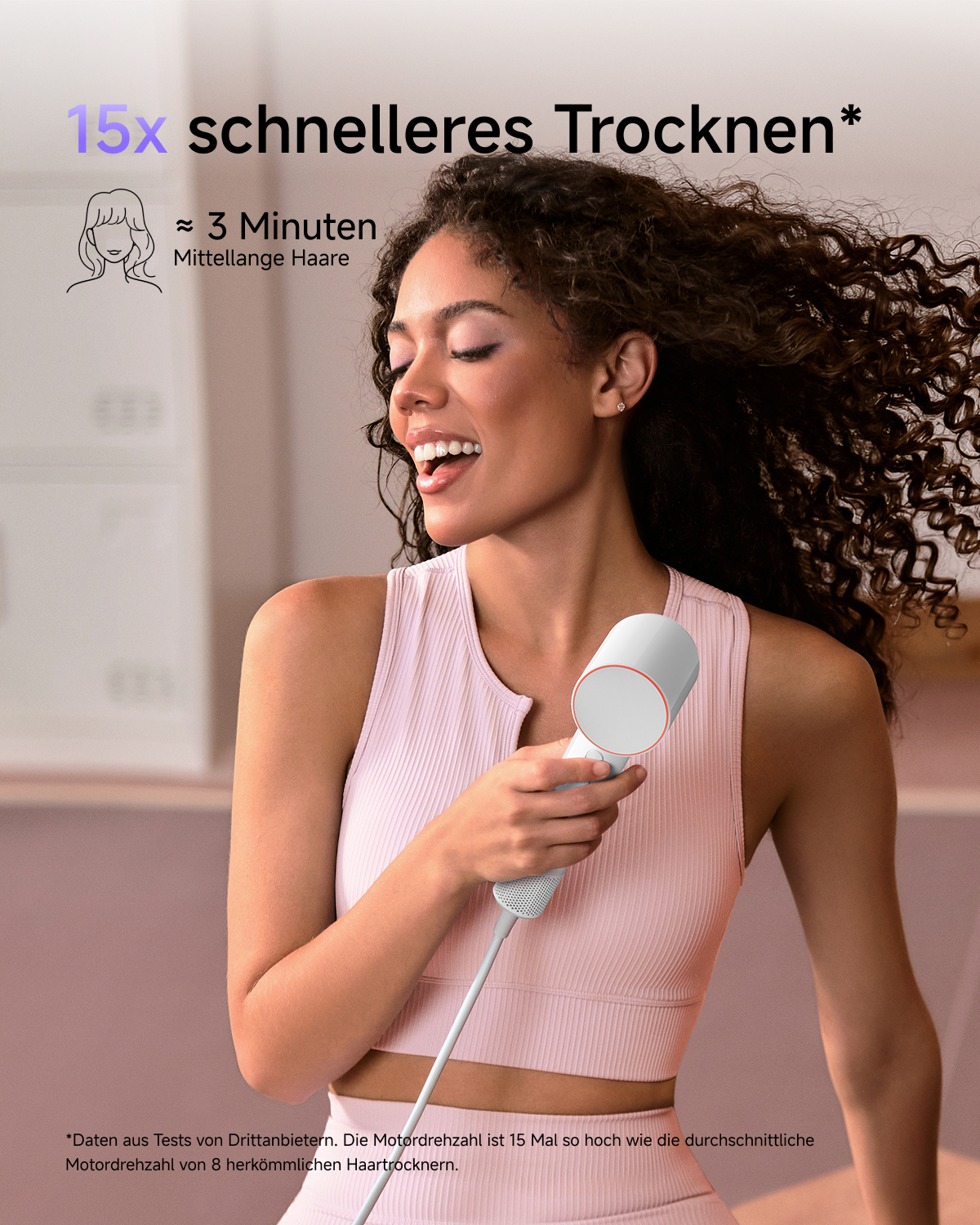 Eine Frau mit lockigem Haar singt in einen weißen Haartrockner als wäre es ein Mikrofon.