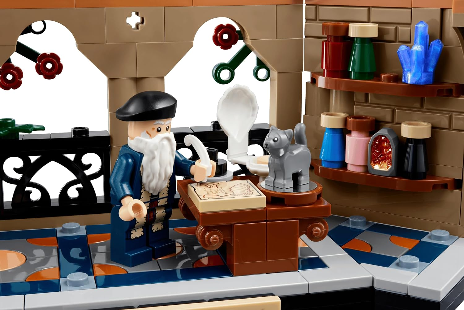 Lego-Figur mit Bart an einem Tisch mit Karte, einer kleinen grauen Katze und Regalen voller magischer Tränke.