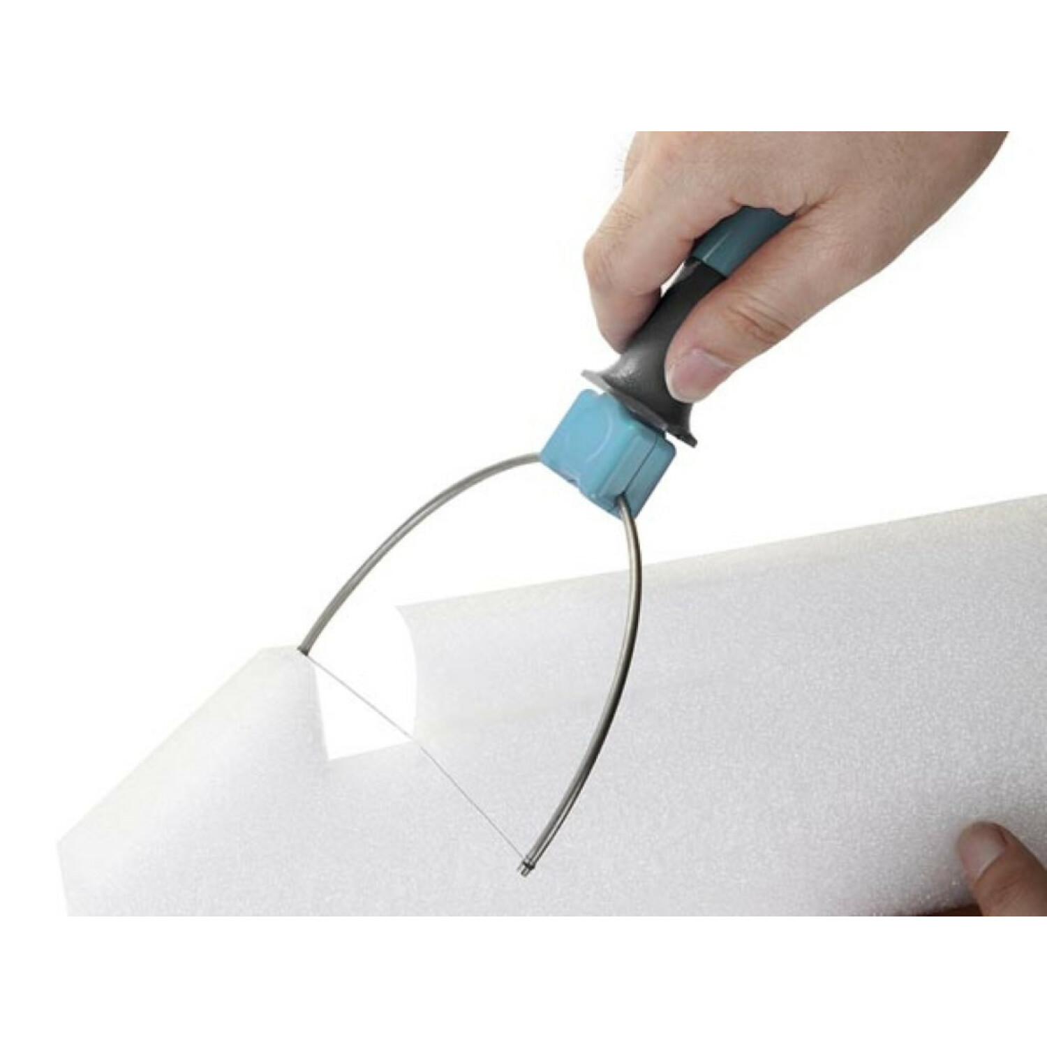 Eine Hand schneidet mit einem speziellen Bügelschneider ein weißes Schaumstoffmaterial.