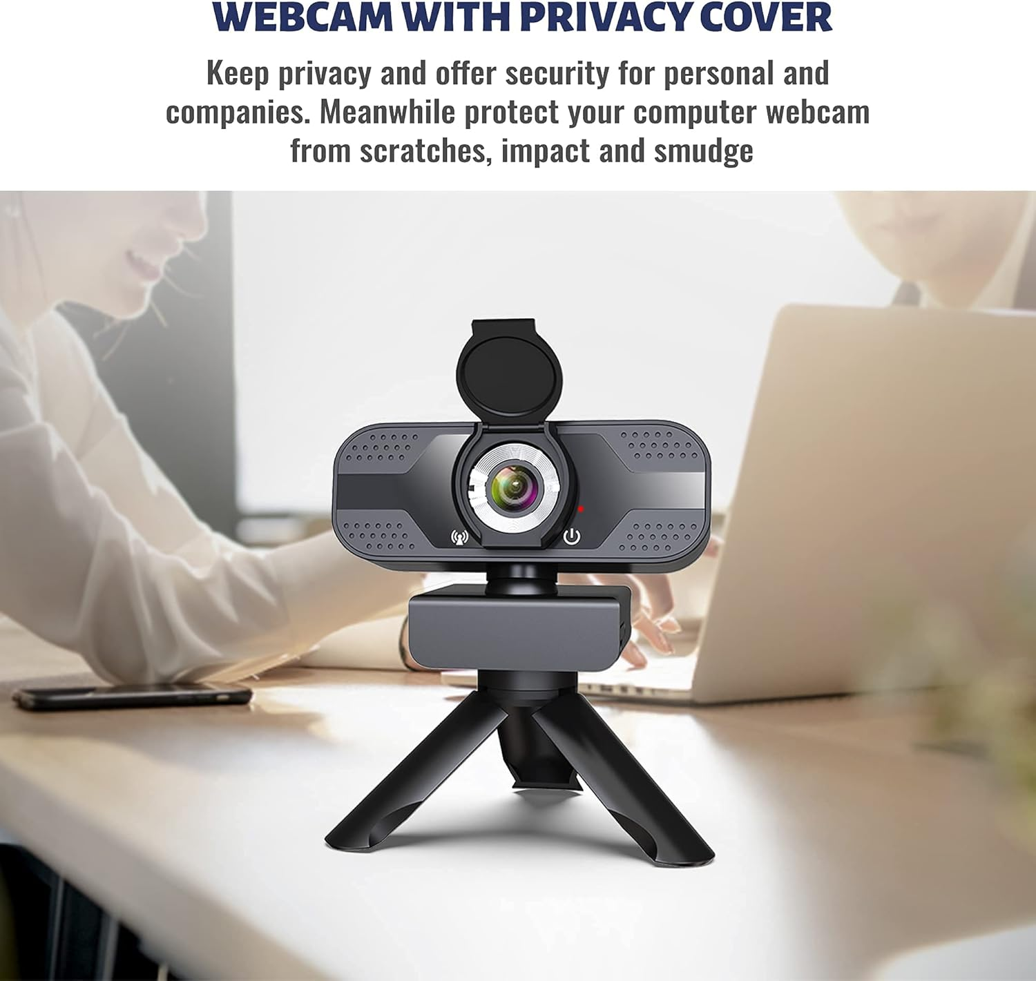 Eine Webcam mit Sichtschutz auf Stativ auf einem Schreibtisch, verschwommener Hintergrund mit zwei arbeitenden Personen.