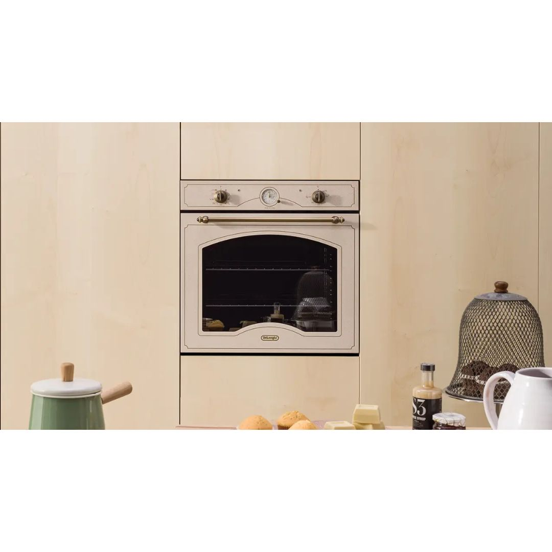 Un forno color crema in mobili in legno chiaro, circondato da utensili da cucina e prodotti da forno.