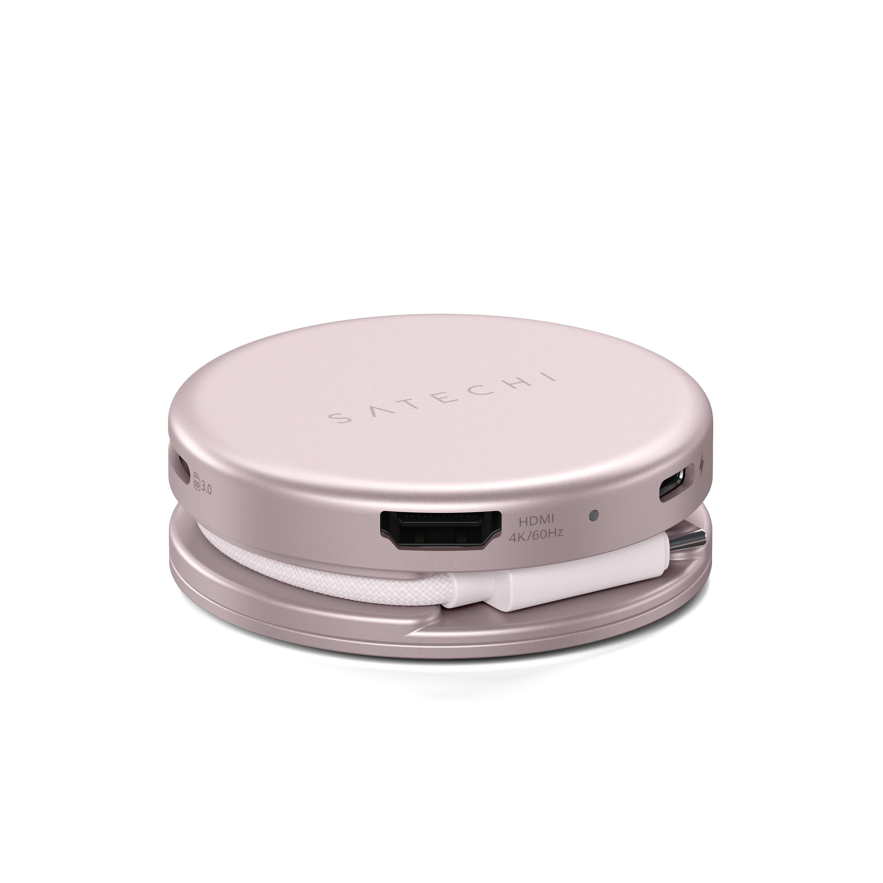 Okrągły, różowy hub USB-C Satechi z różnymi portami i owiniętym białym kablem na białym tle.