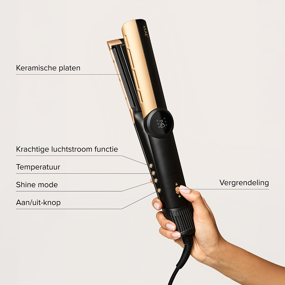 Hand holding a black and gold hair straightener with feature labels on a light background.