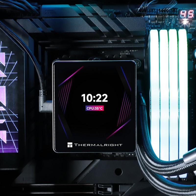 Placa base con un disipador de CPU digital que muestra la hora, junto a módulos de RAM blancos.
